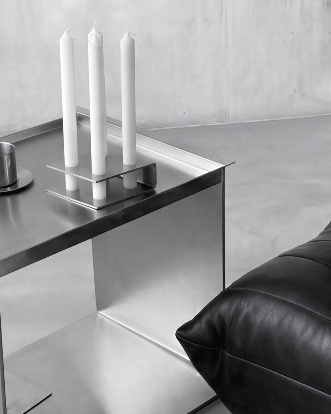 Object Holder auf einem Edelstahl-Beistelltisch neben einem Ledersofa