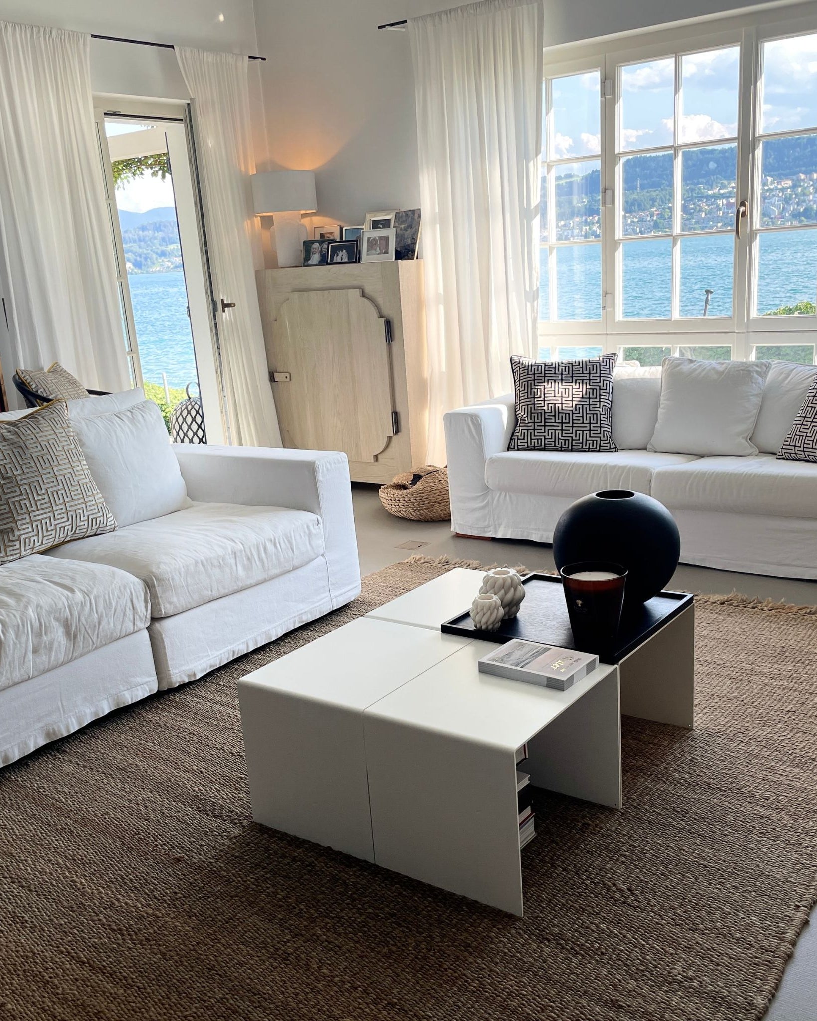 4-teiliger_Couchtisch_Big_C4 im Wohnzimmer weiße Couch Bücher und Kerzen See und Fenster