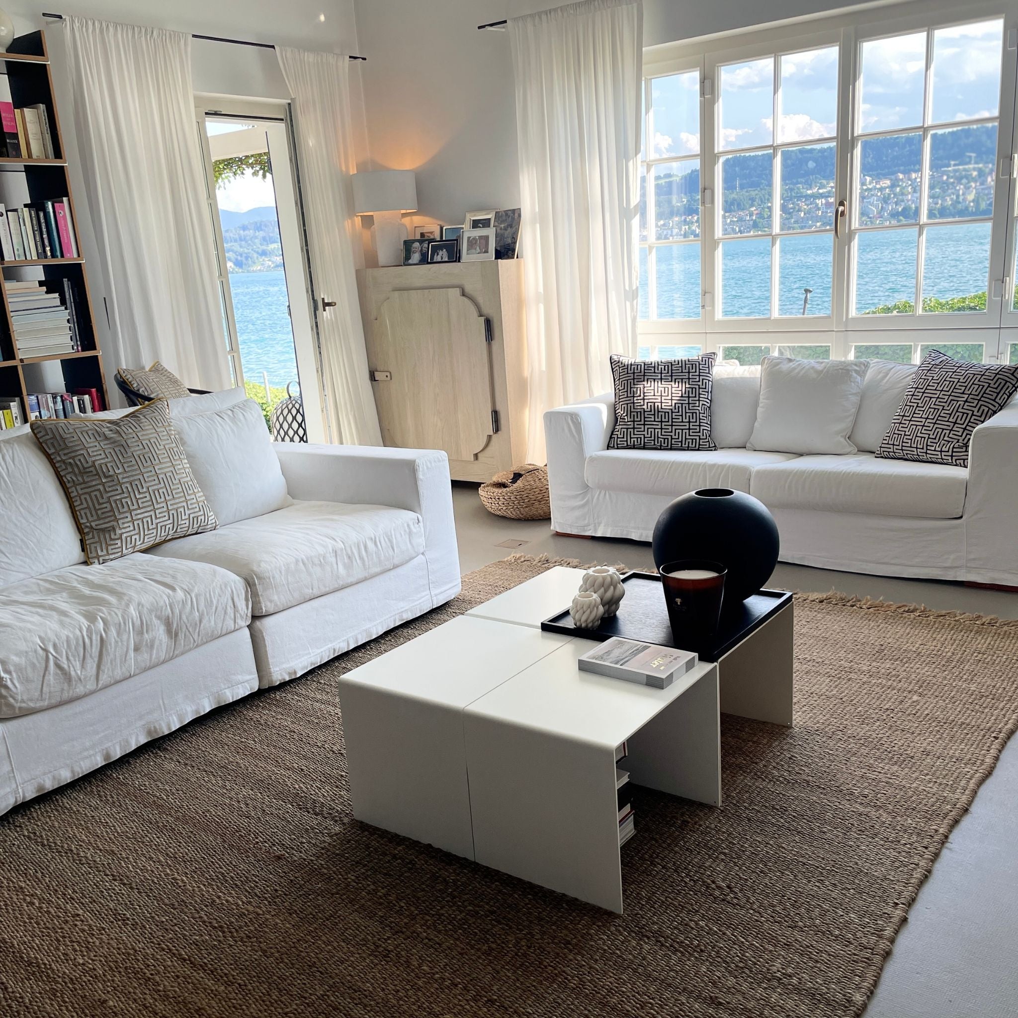 4-teiliger_Couchtisch_Big_C4 im Wohnzimmer weiße Couch Bücher und Kerzen See und Fenster