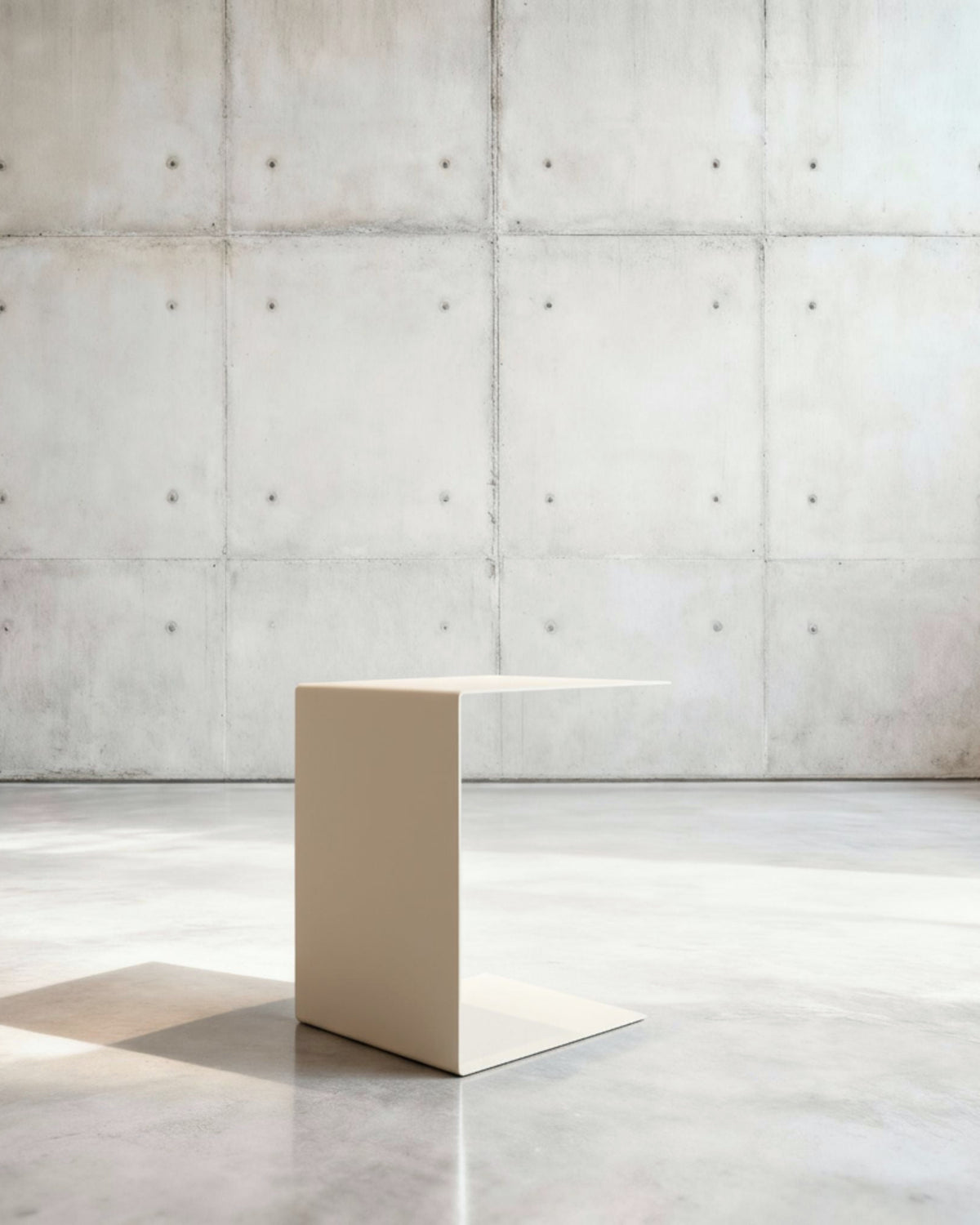 Minimalistischer Beistelltisch BIG C aus cremeweiß matt lackiertem Stahl in architektonischem Raum auf Betonboden