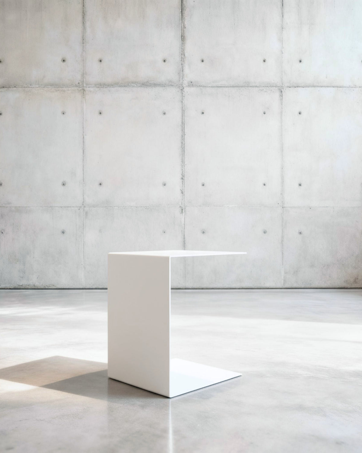 Minimalistischer Beistelltisch BIG C aus weiß matt lackiertem Stahl in architektonischem Raum auf Betonboden