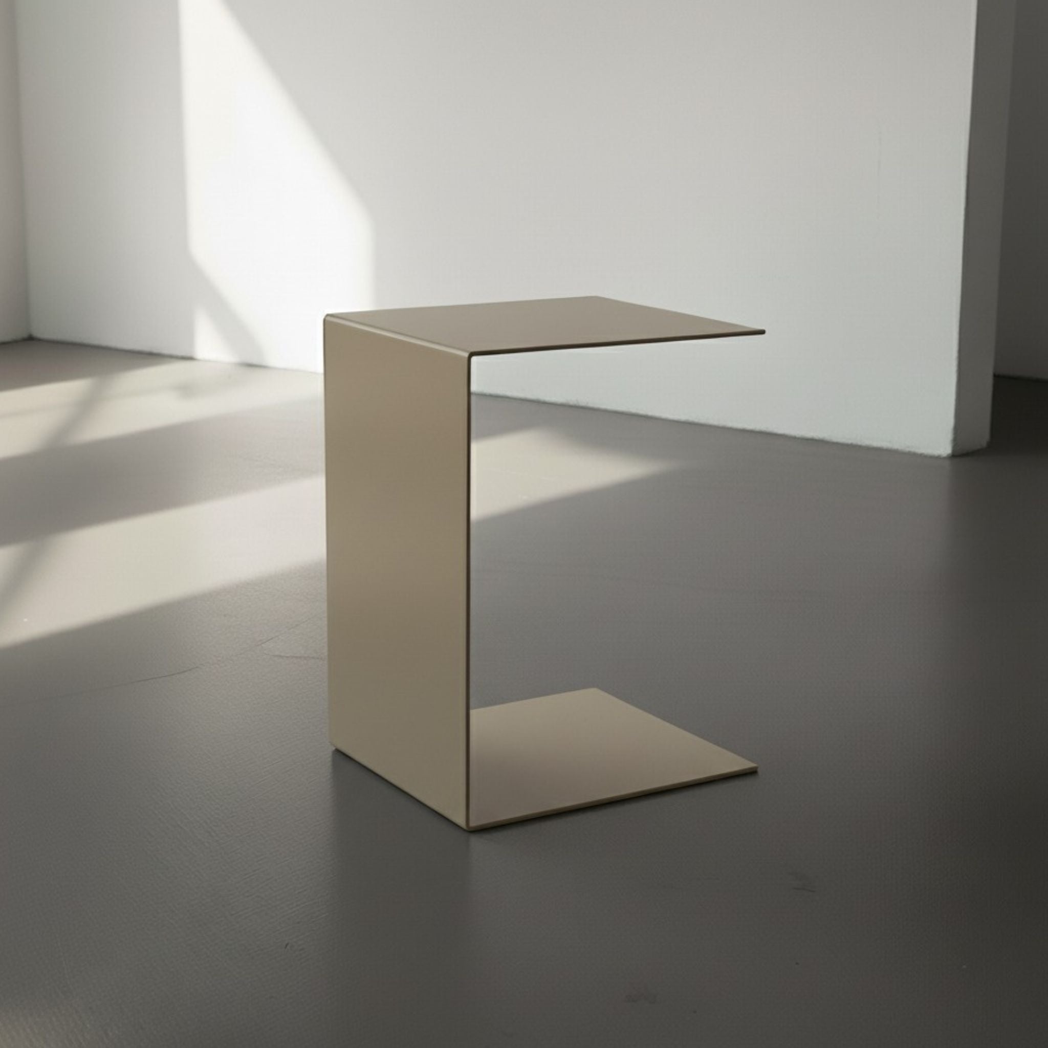 BIG C in graubeige auf grauen Betonboden vor weißer Wand und Lichtspiel