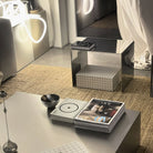 Spiegelpolierter Beistelltisch neben einem Couchtisch aus Edelstahl in einem stilvollen Wohnzimmer-Setting mit dekorativen Elementen