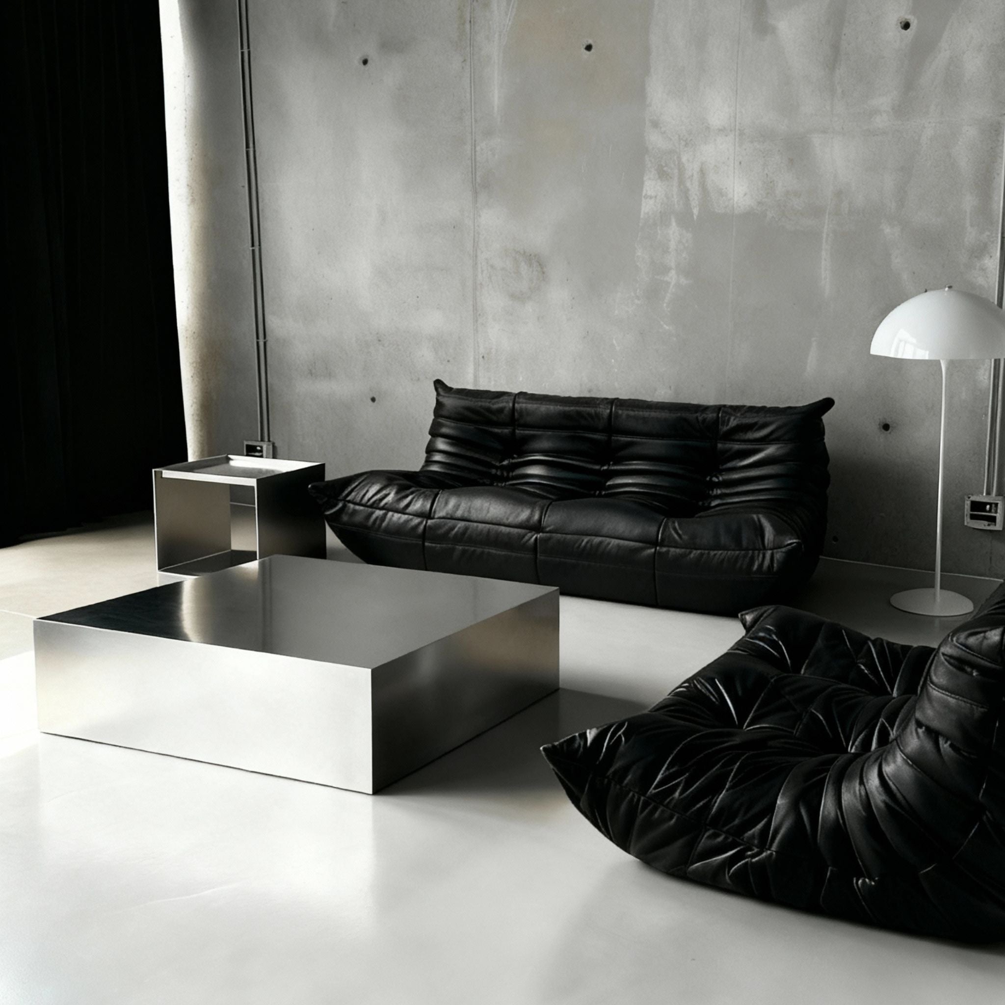 Brushed Q vor Betonwand auf Betonboden mit schwarzem lignet rose Sofa aus Leder
