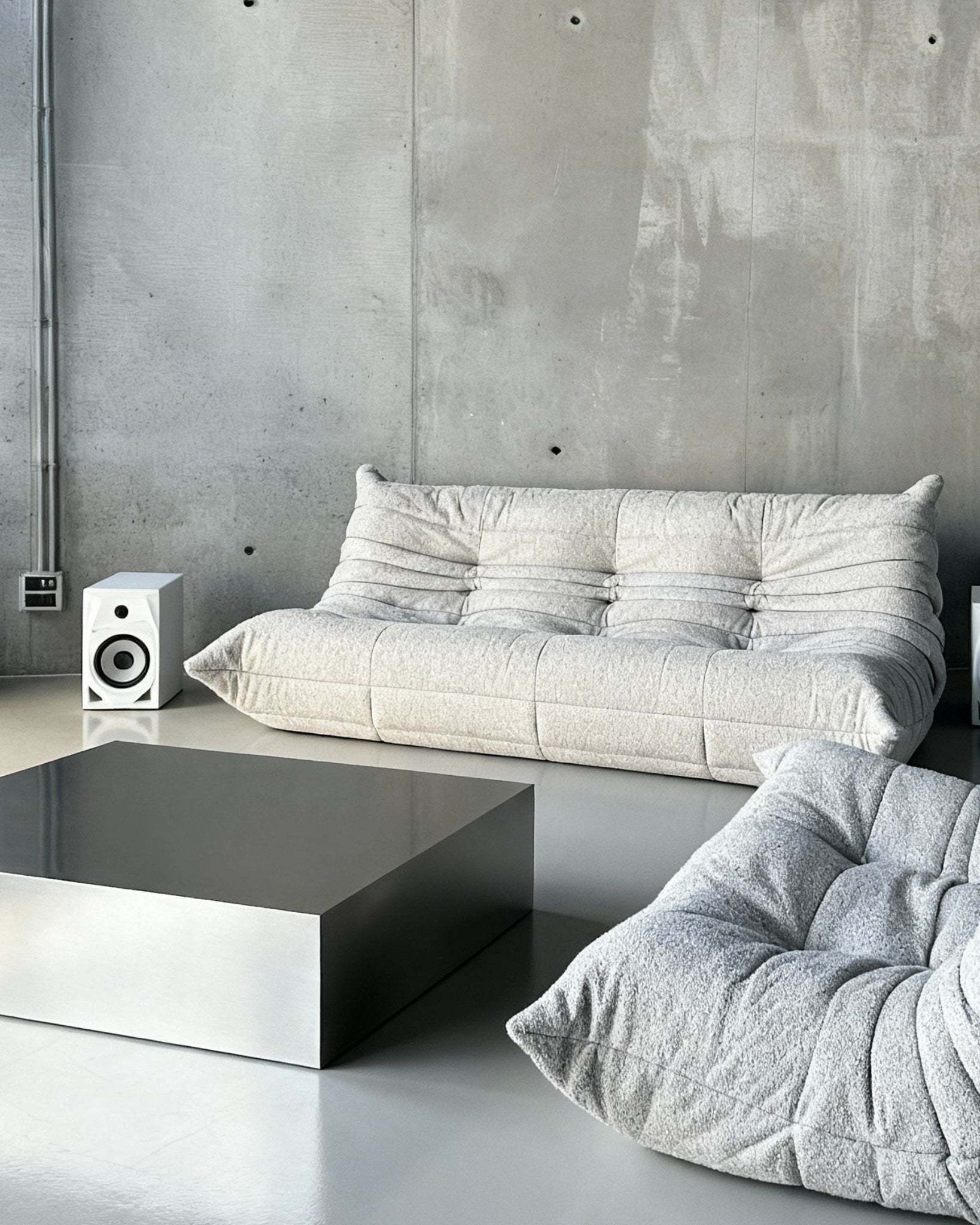 Brushed Q vor Betonwand auf Betonboden mit weissem lignet rose Sofa