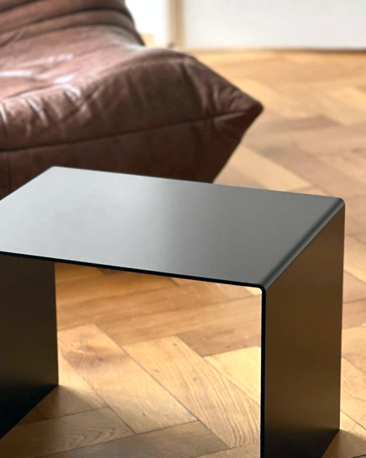 Schwarzer minimalistischer Beistelltisch aus Metall auf Parkettboden, modernes Wohnzimmerdesign