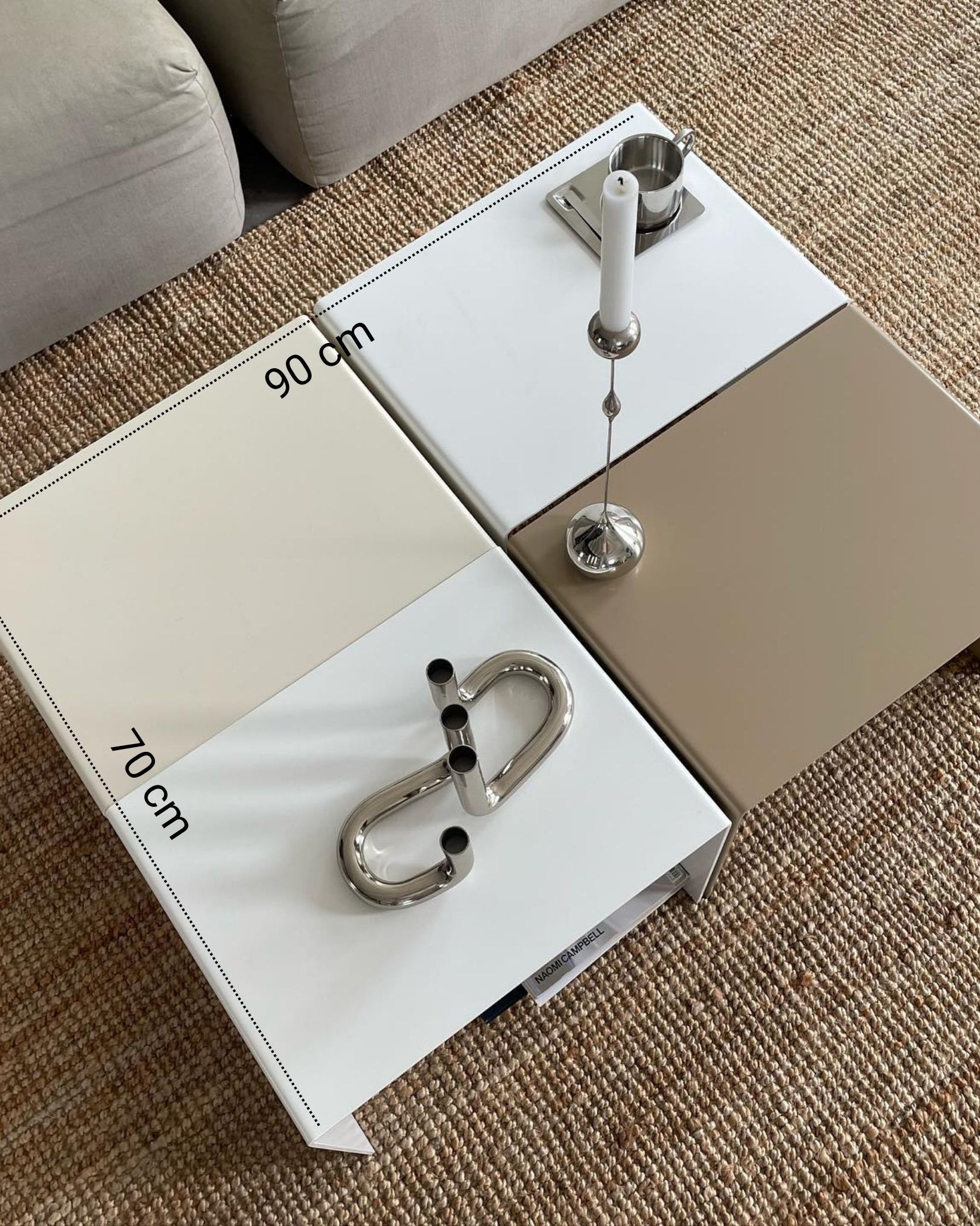 Vier kombinierte Couchtische in Weiß, Graubeige und Cremeweiß mit Maßangaben von 90 cm x 70 cm, dekoriert mit Edelstahl-Accessoires.