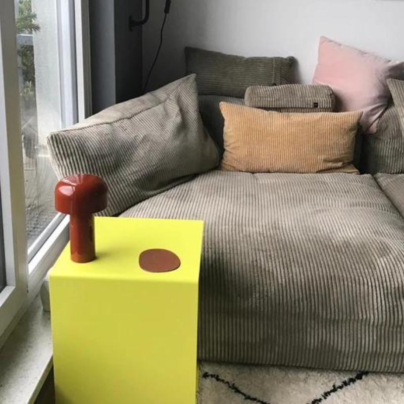 Kundenfoto - gelber Beistelltisch mit roter Lampe neben grauen Cordsofa