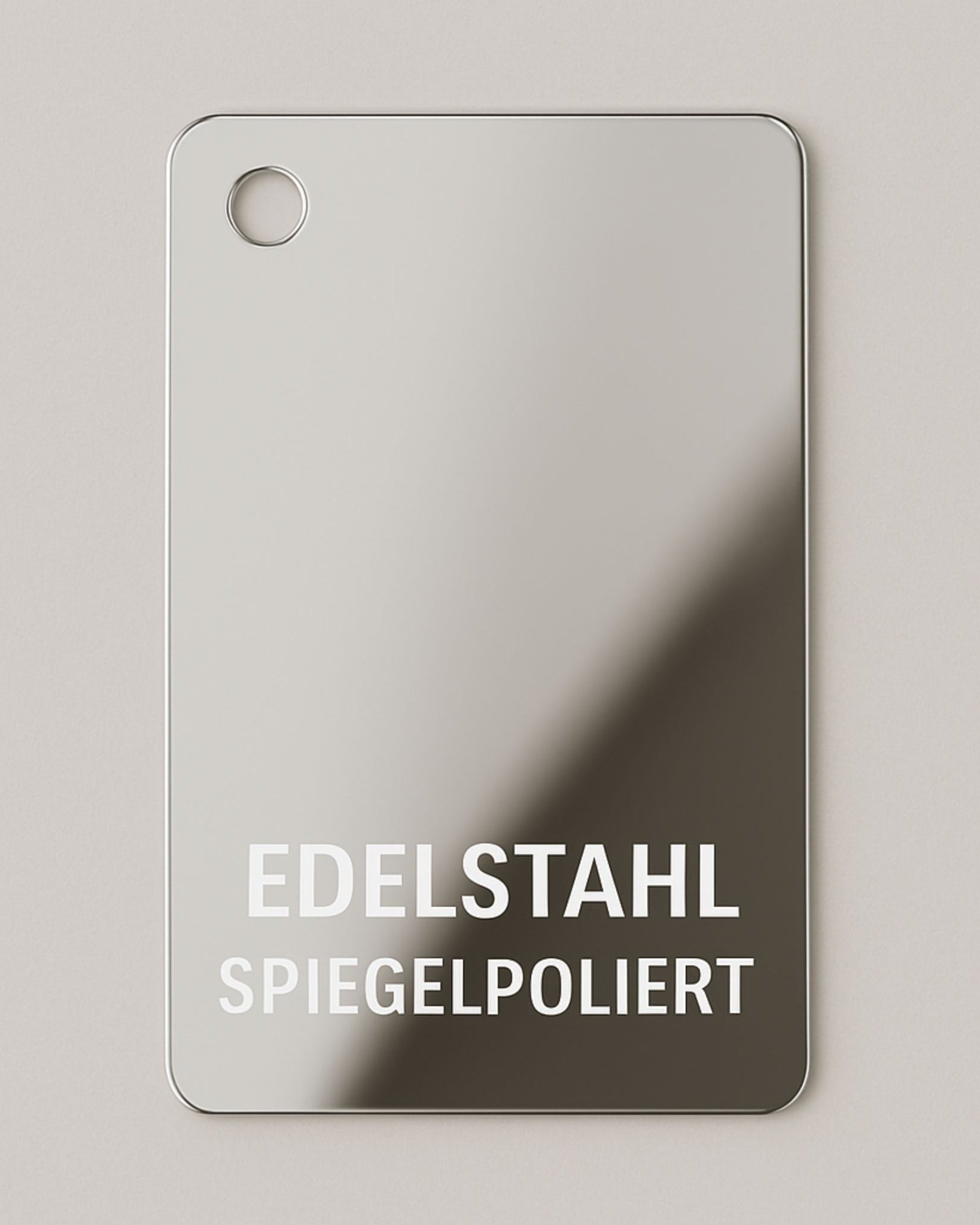 Materialmuster aus spiegelpoliertem Edelstahl von MO INTERIORS mit runden Ecken und Bohrung oben links, für Möbel und Designobjekte