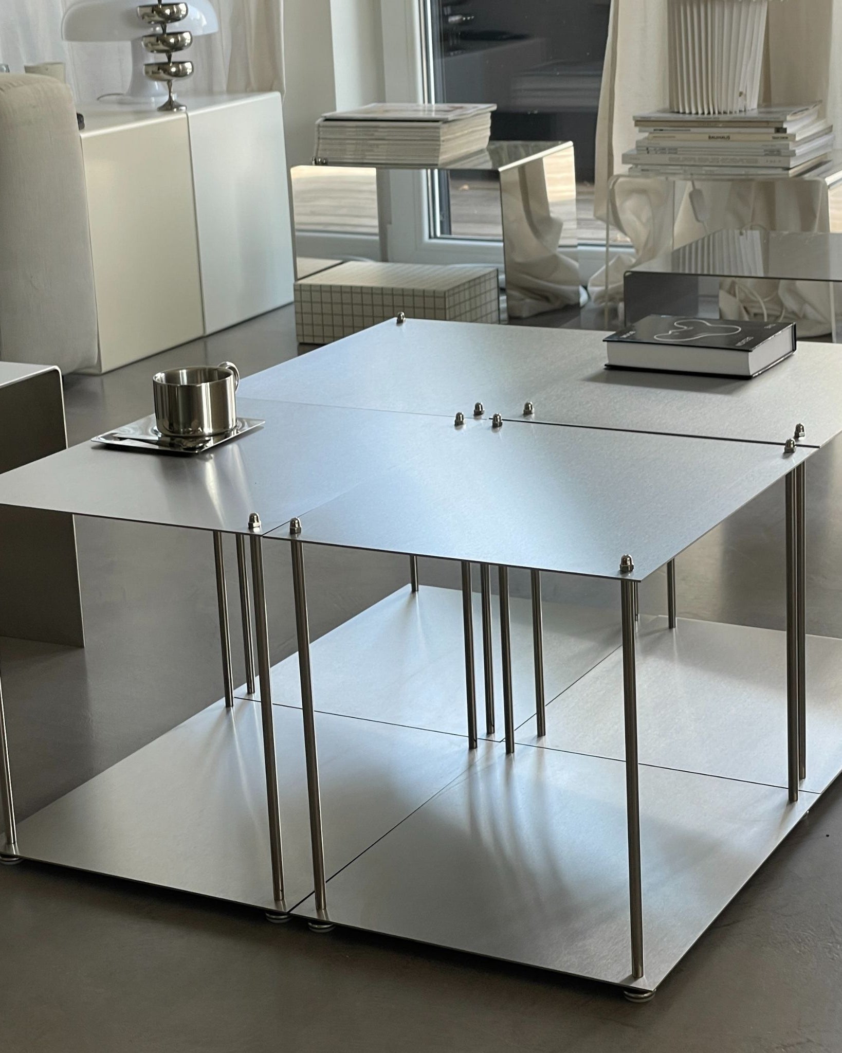 Vier Modulum-Module aus gebürstetem Edelstahl, arrangiert als quadratischer Couchtisch im Wohnraum