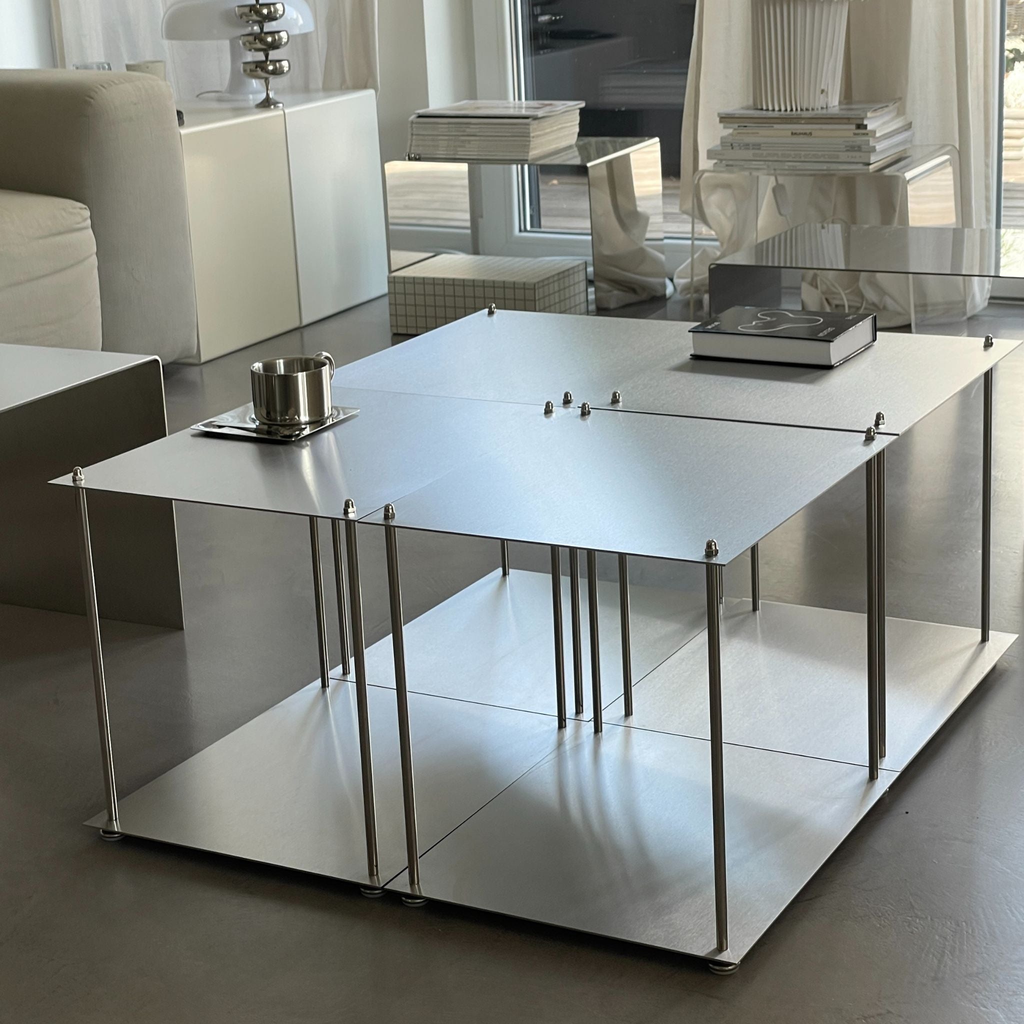 Vier Modulum-Module aus gebürstetem Edelstahl, arrangiert als quadratischer Couchtisch im Wohnraum