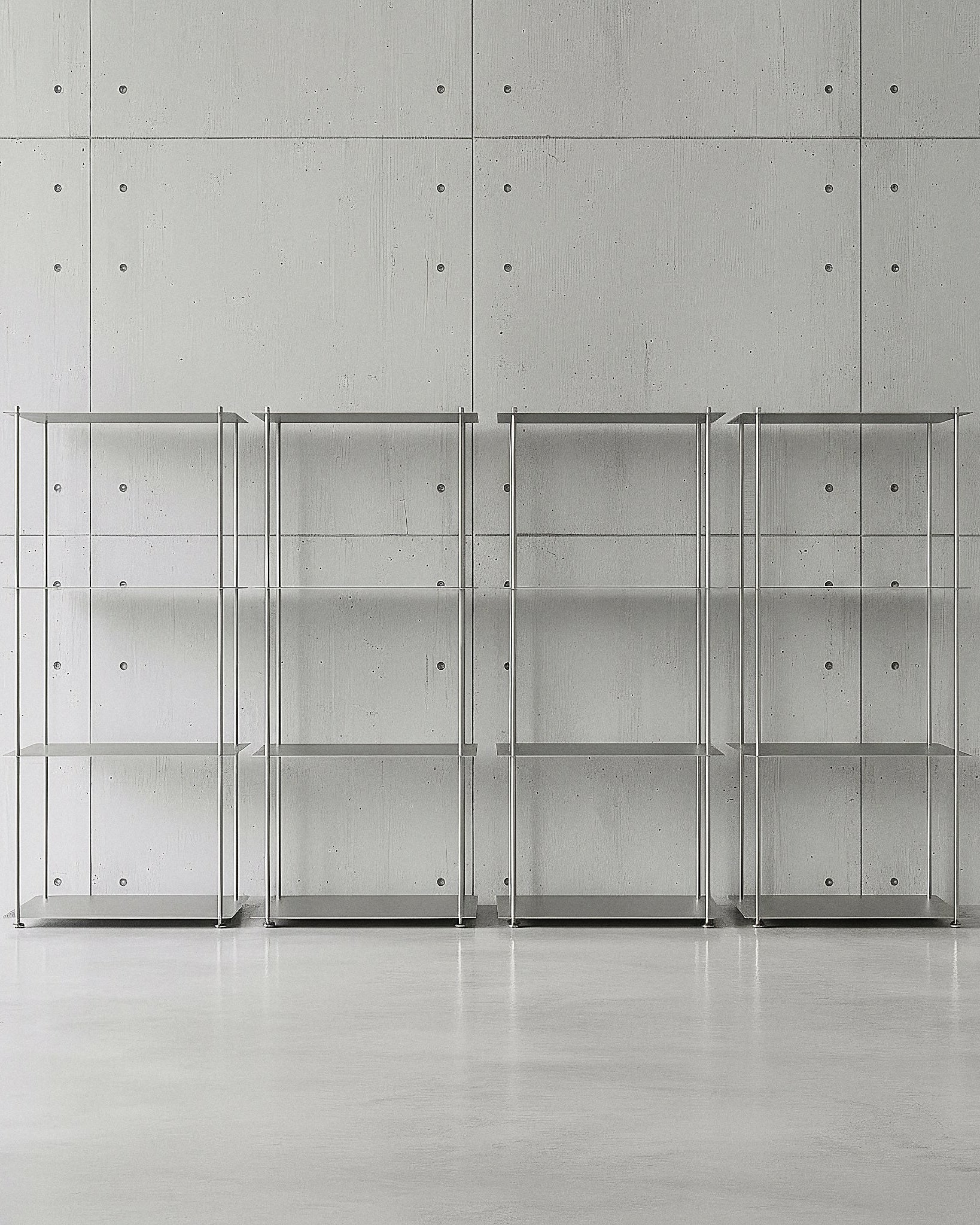Modulum mit 4 Fachböden als Regalwand in Edelstahl auf Betonboden vor Betonwand