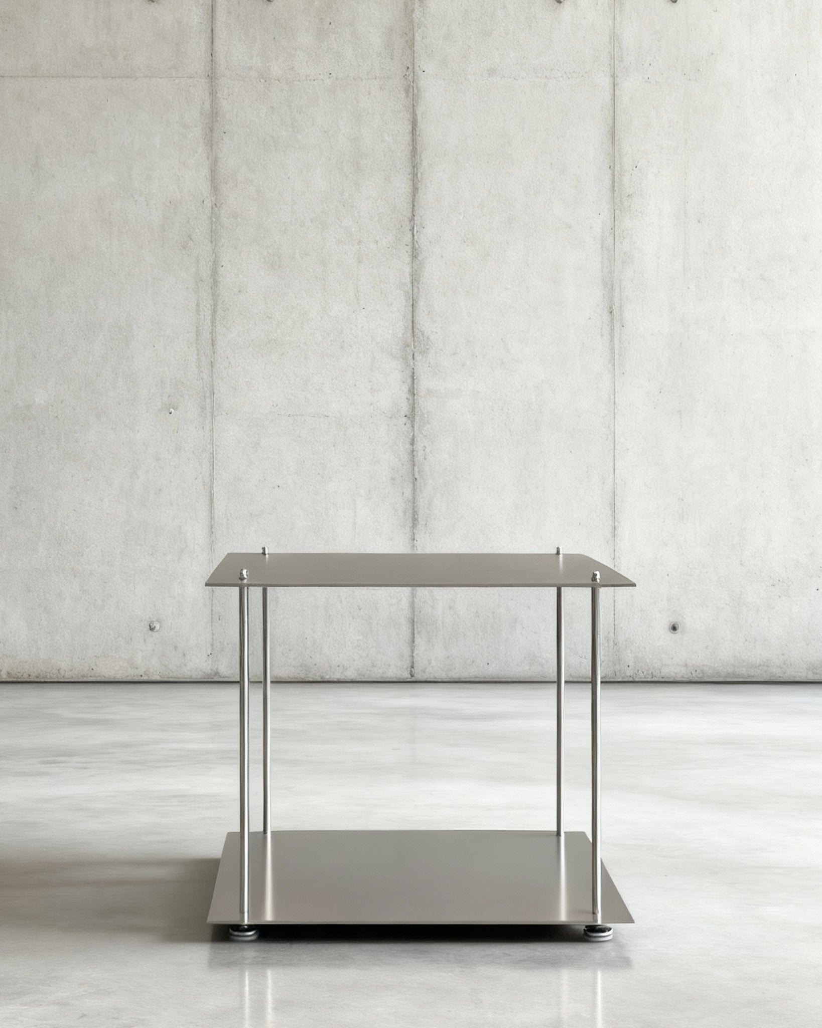 Modulum Basismodull in gebürstetem Edelstahl  auf grauen Betonboden vor grauer Betonwand mit Löchern