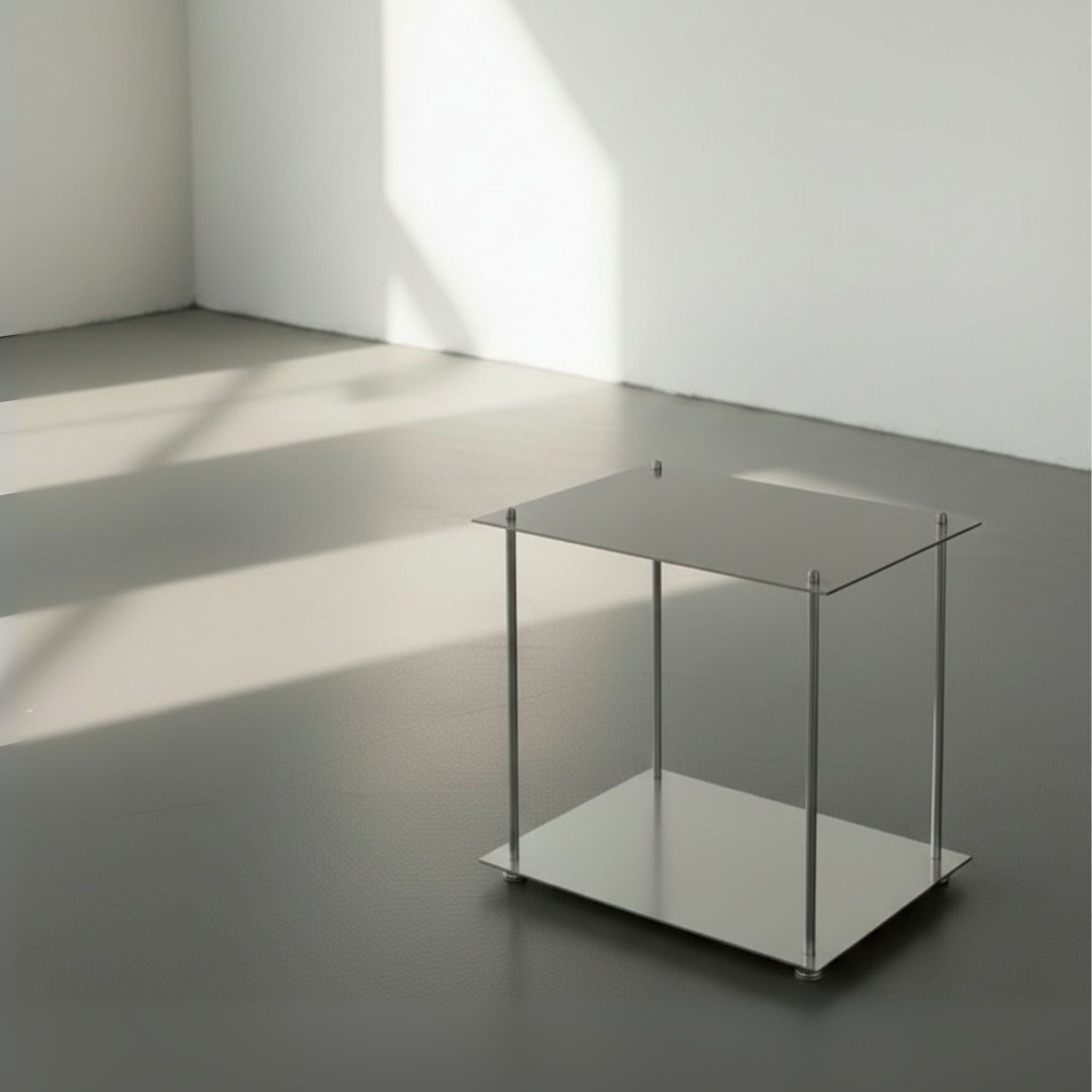 Modulum Basismodul aus gebürstetem Edelstahl auf grauen Betonboden vor weißer Wand und Lichtspiel