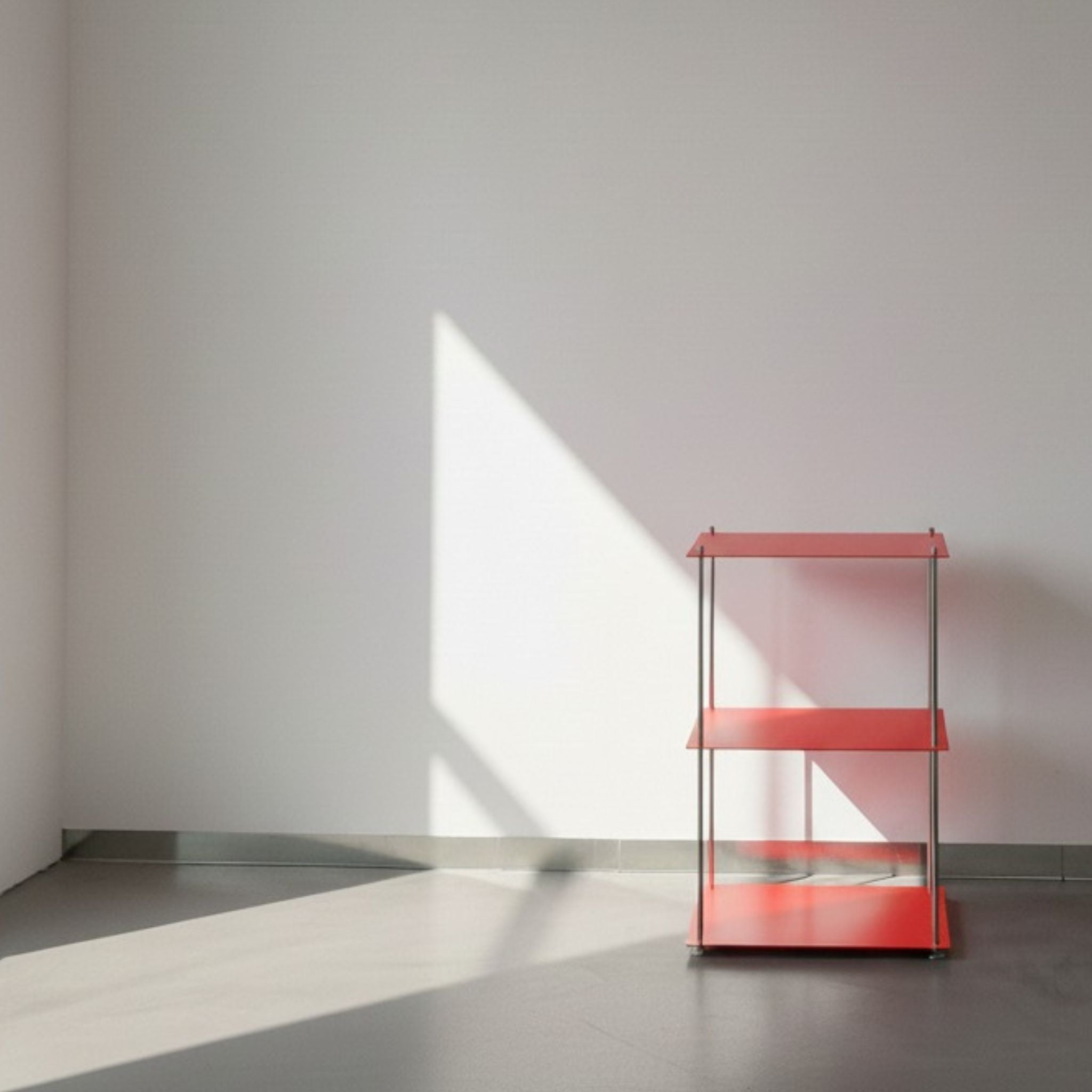 Modulum in leuchtrot mit 3 Fachböden auf grauen Betonboden vor weißer Wand und Lichtspiel