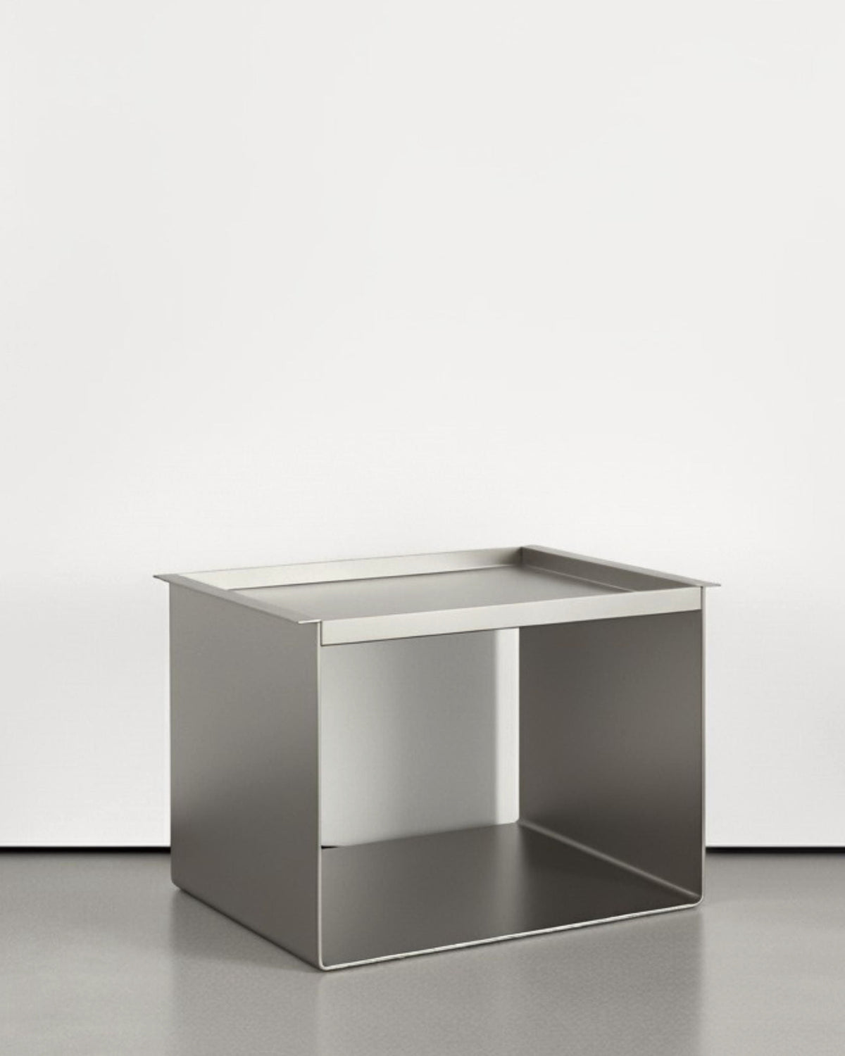 Tray Table Brushed C aus Edelstahl gebürstet auf grauen Betonboden vor weißer Wand und Lichtspiel