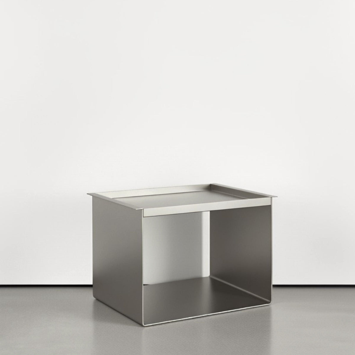 Tray Table Brushed C aus Edelstahl gebürstet auf grauen Betonboden vor weißer Wand und Lichtspiel