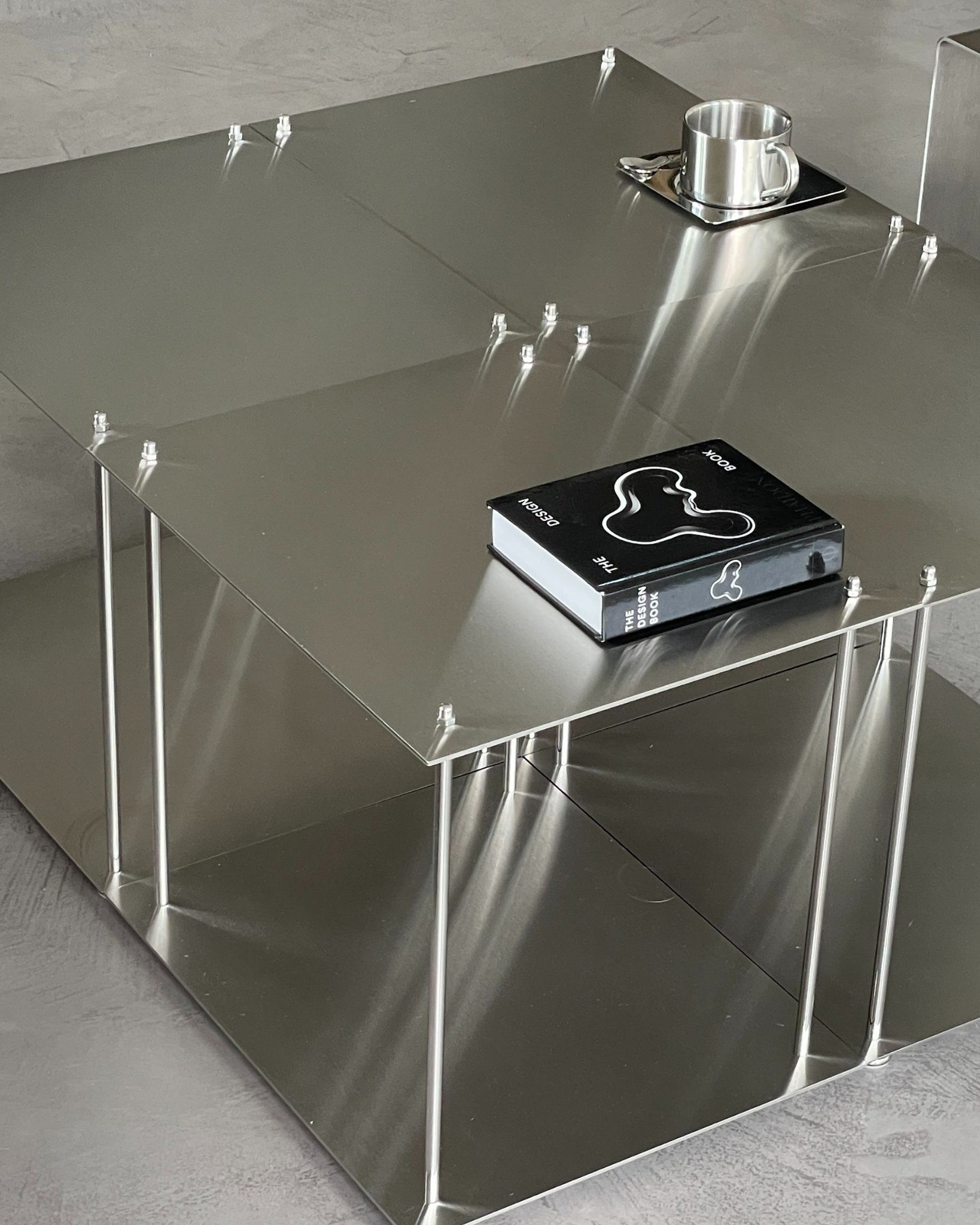 Vier Modulum-Module aus gebürstetem Edelstahl, kombiniert zu einem Design Couchtisch im Wohnzimmer