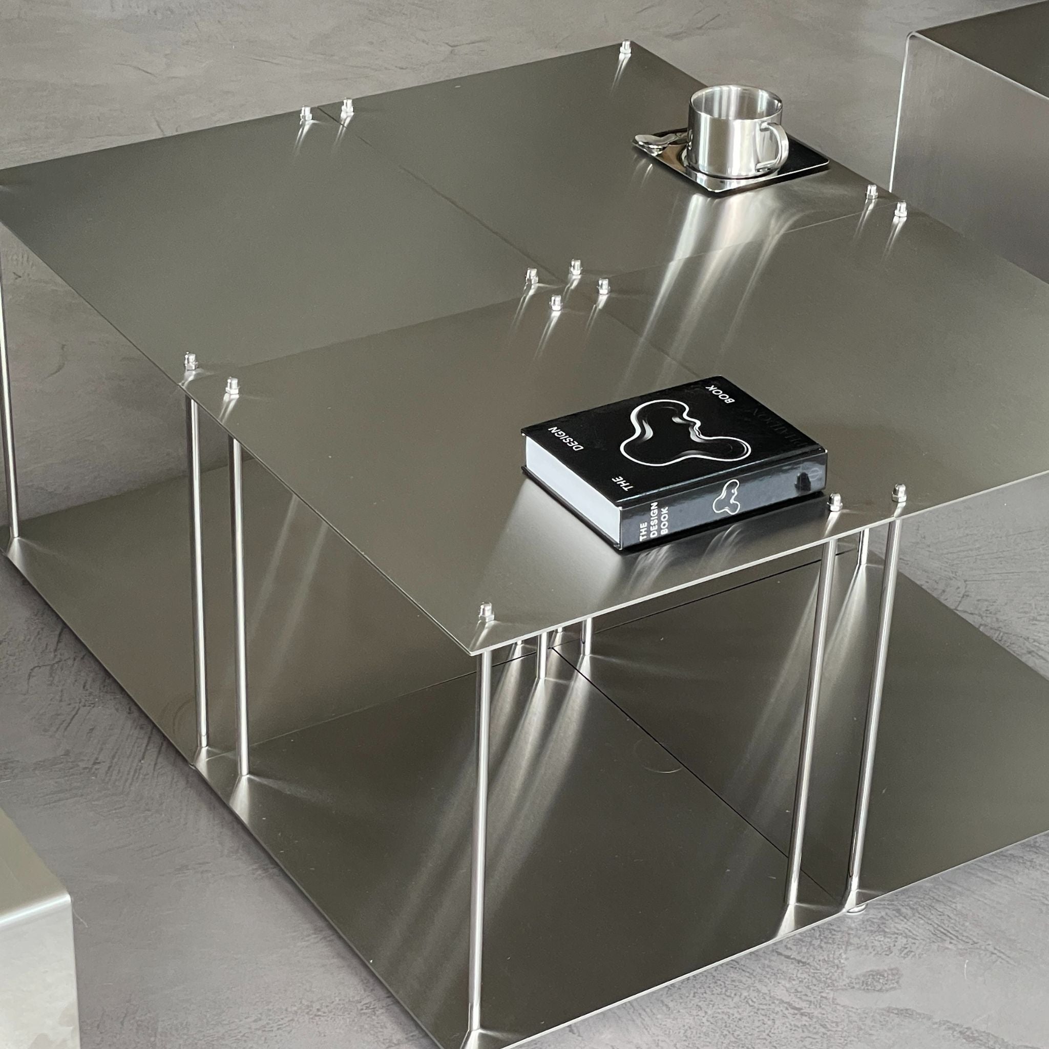 Vier Modulum-Module aus gebürstetem Edelstahl, kombiniert zu einem Design Couchtisch im Wohnzimmer