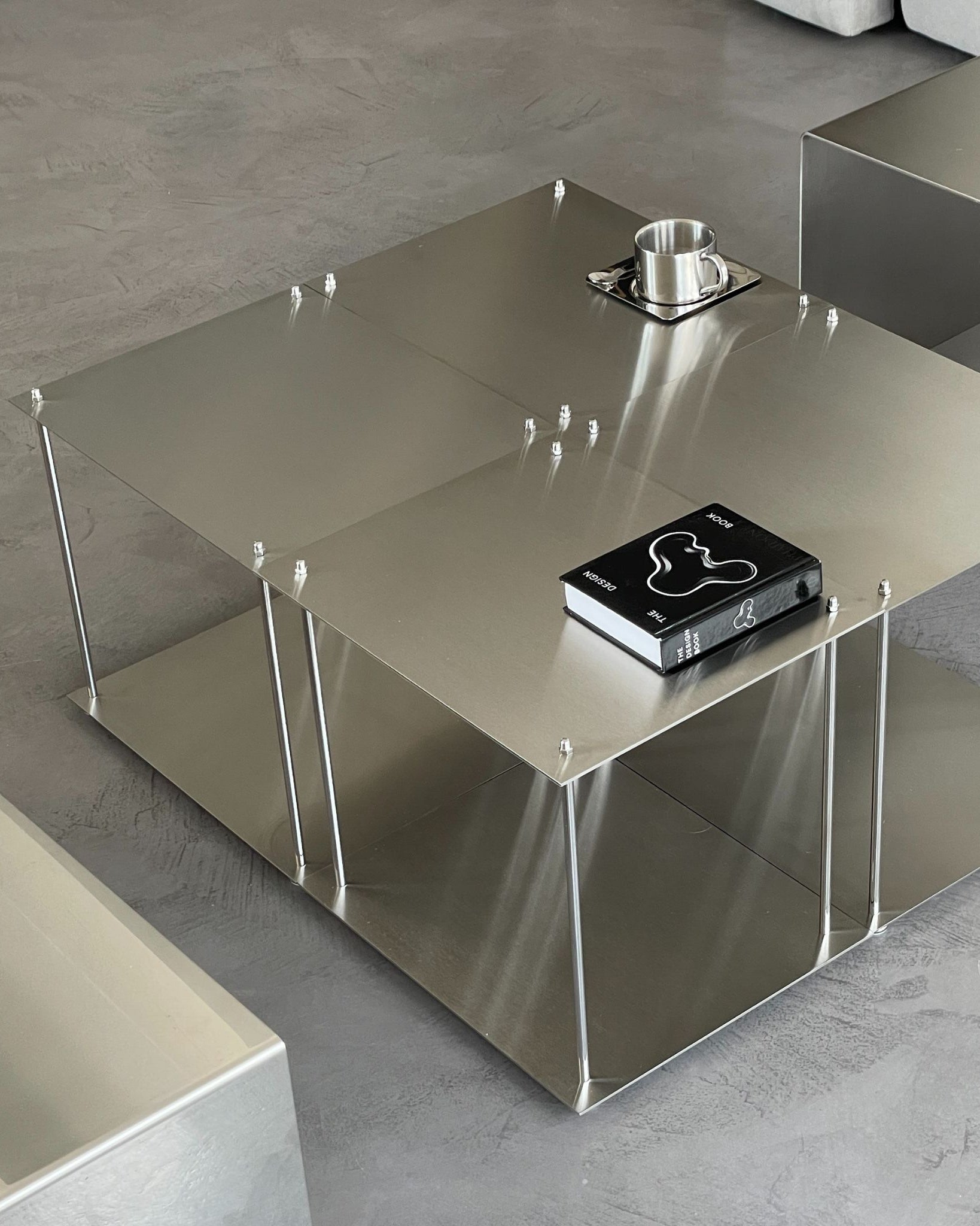 Vier quadratische Modulum-Module aus gebürstetem Edelstahl, kombiniert zu einem modernen Couchtisch im Wohnzimmer