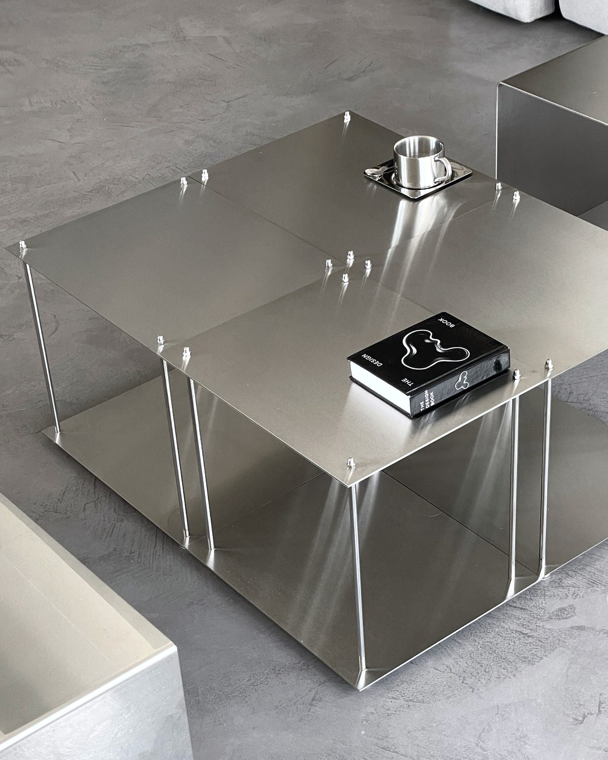 Vier quadratische Modulum-Module aus gebürstetem Edelstahl, kombiniert zu einem modernen Couchtisch im Wohnzimmer