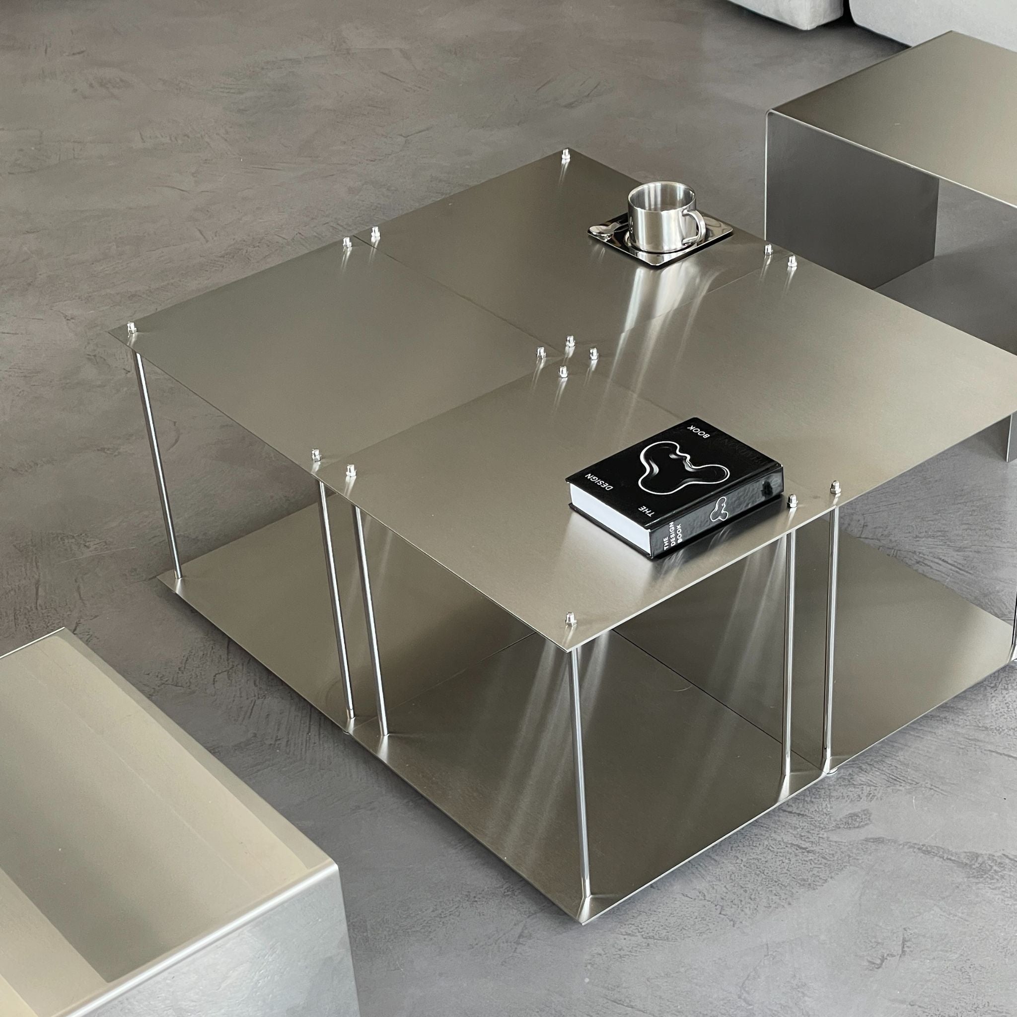 Vier quadratische Modulum-Module aus gebürstetem Edelstahl, kombiniert zu einem modernen Couchtisch im Wohnzimmer