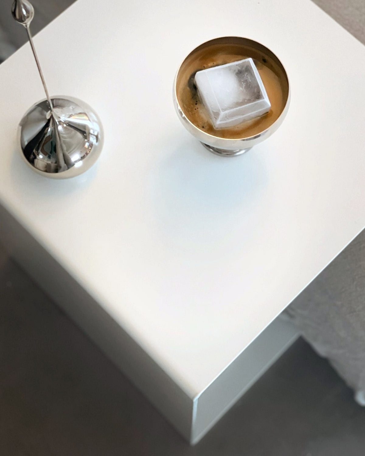 Weißer minimalistischer Beistelltisch mit Edelstahl-Dekoration und Kaffee