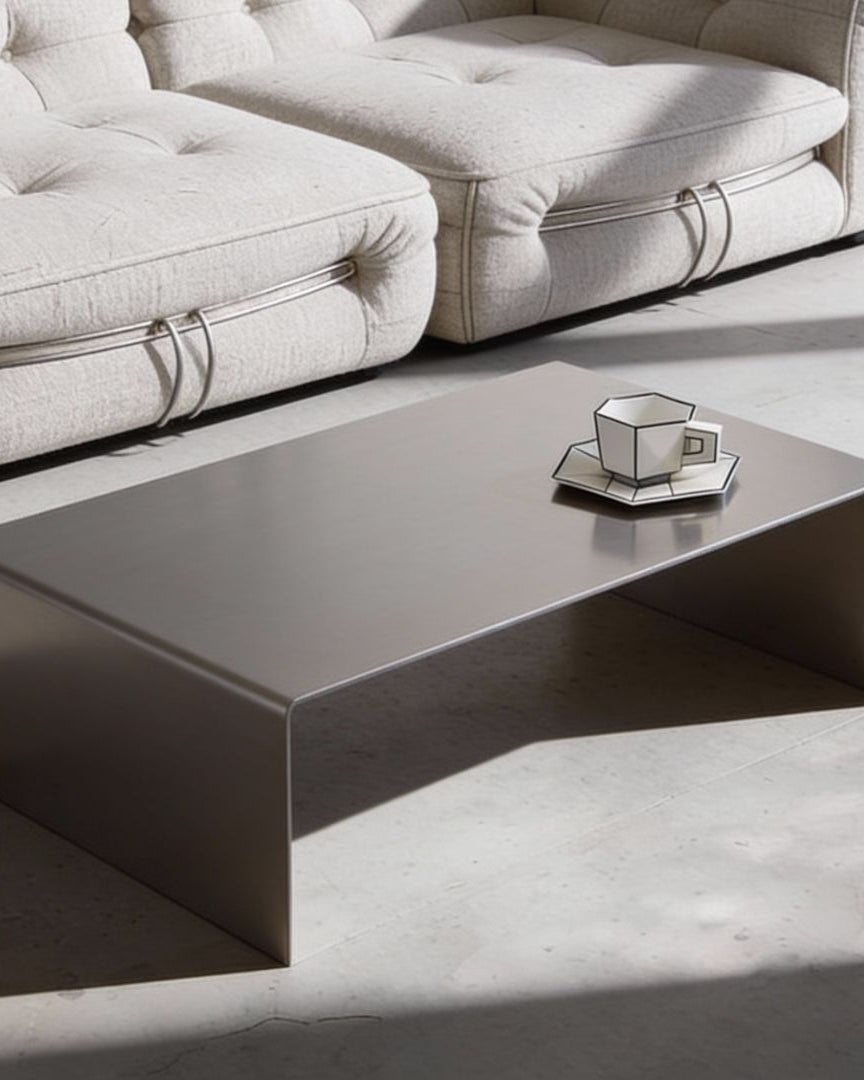 Brushed C Long Couchtisch aus gebürstetem Edelstahl vor Sofa inszeniert, minimalistisches Premium Interior Design