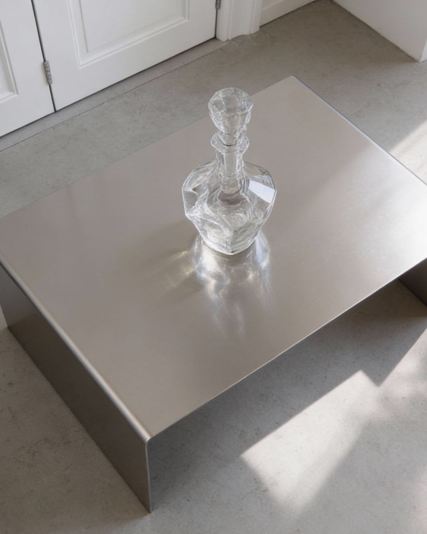 Brushed C Long Couchtisch aus gebürstetem Edelstahl in Draufsicht mit Glasobjekt, minimalistisches Wohnraum-Design