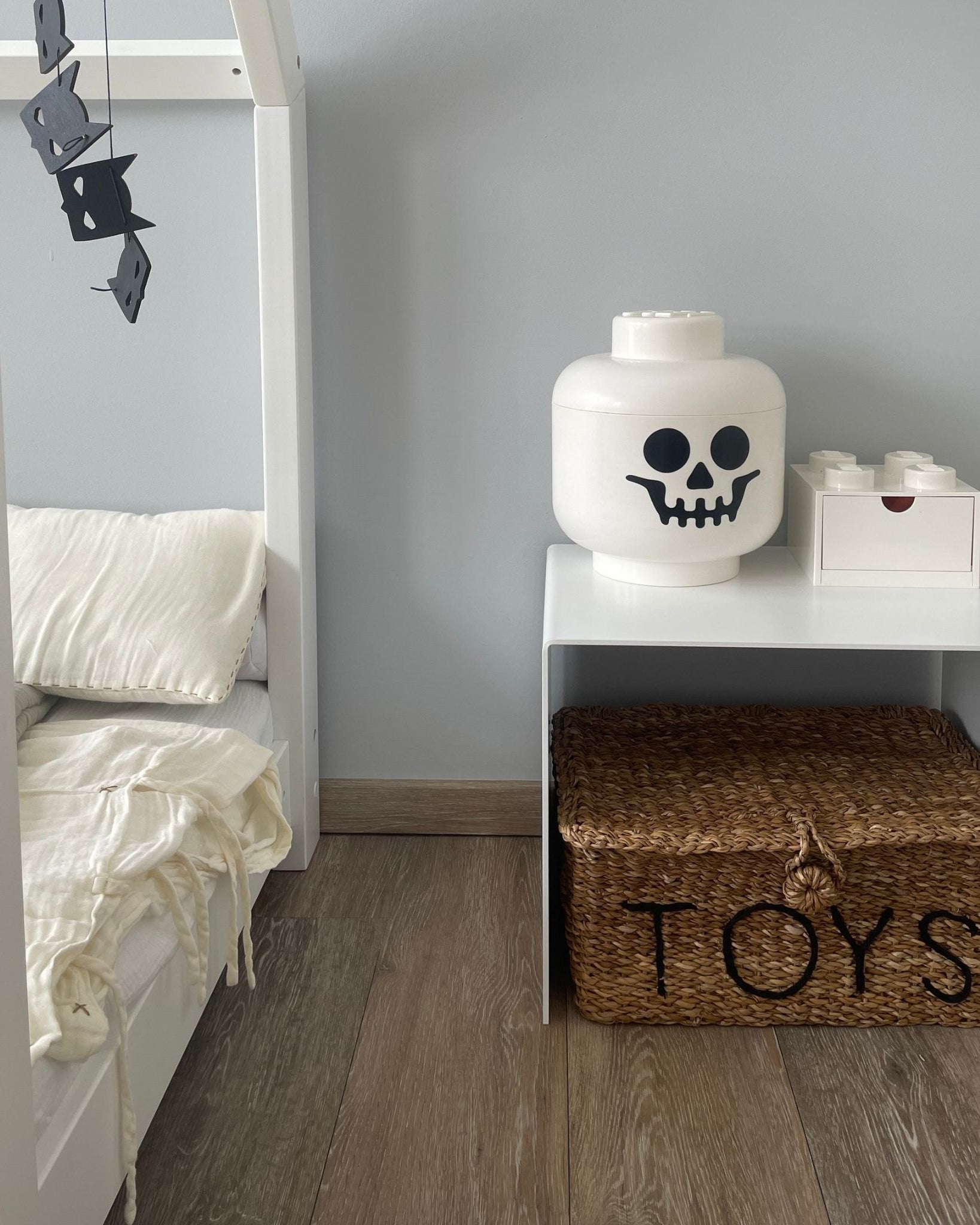 Weißer Couchtisch als Ablage im Kinderzimmer mit Spielzeugkiste und Dekoration auf Holzboden