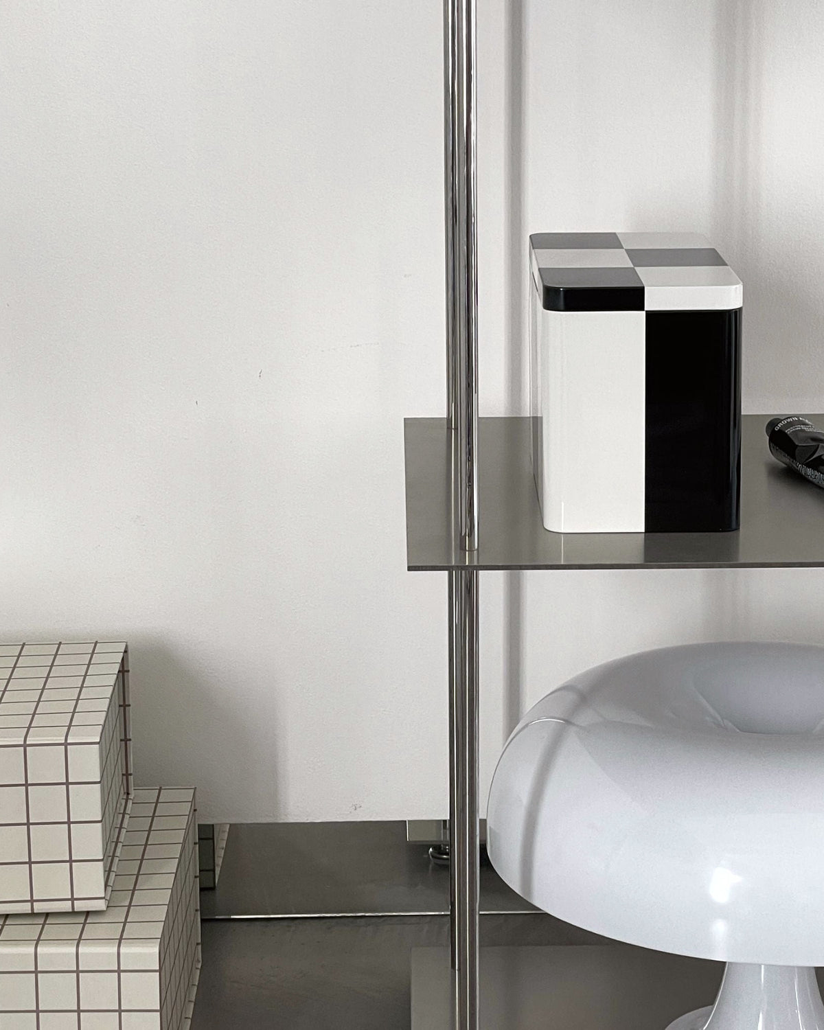 Detailansicht eines modularen Edelstahl-Regals mit Deko-Objekten in modernem Interior