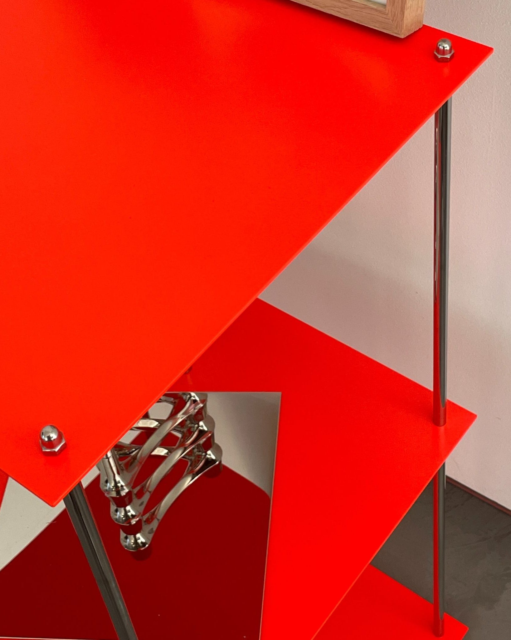 Detailansicht des leuchtroten Designregals mit pulverbeschichteten Böden von MO INTERIORS