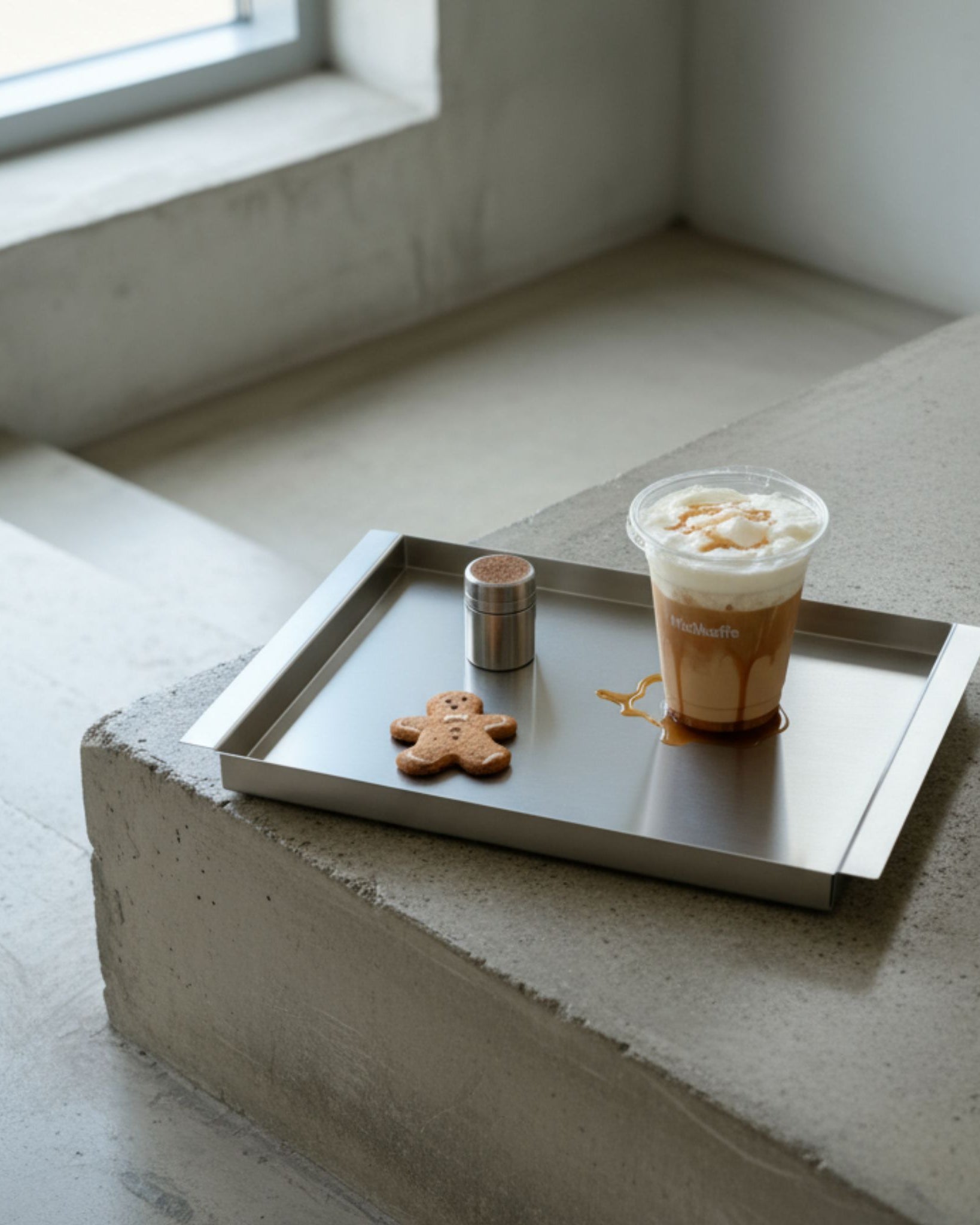 Edelstahl Tablett RAY mit Kaffee und Gebäck auf Betonfläche im minimalistischen Interior von MO INTERIORS