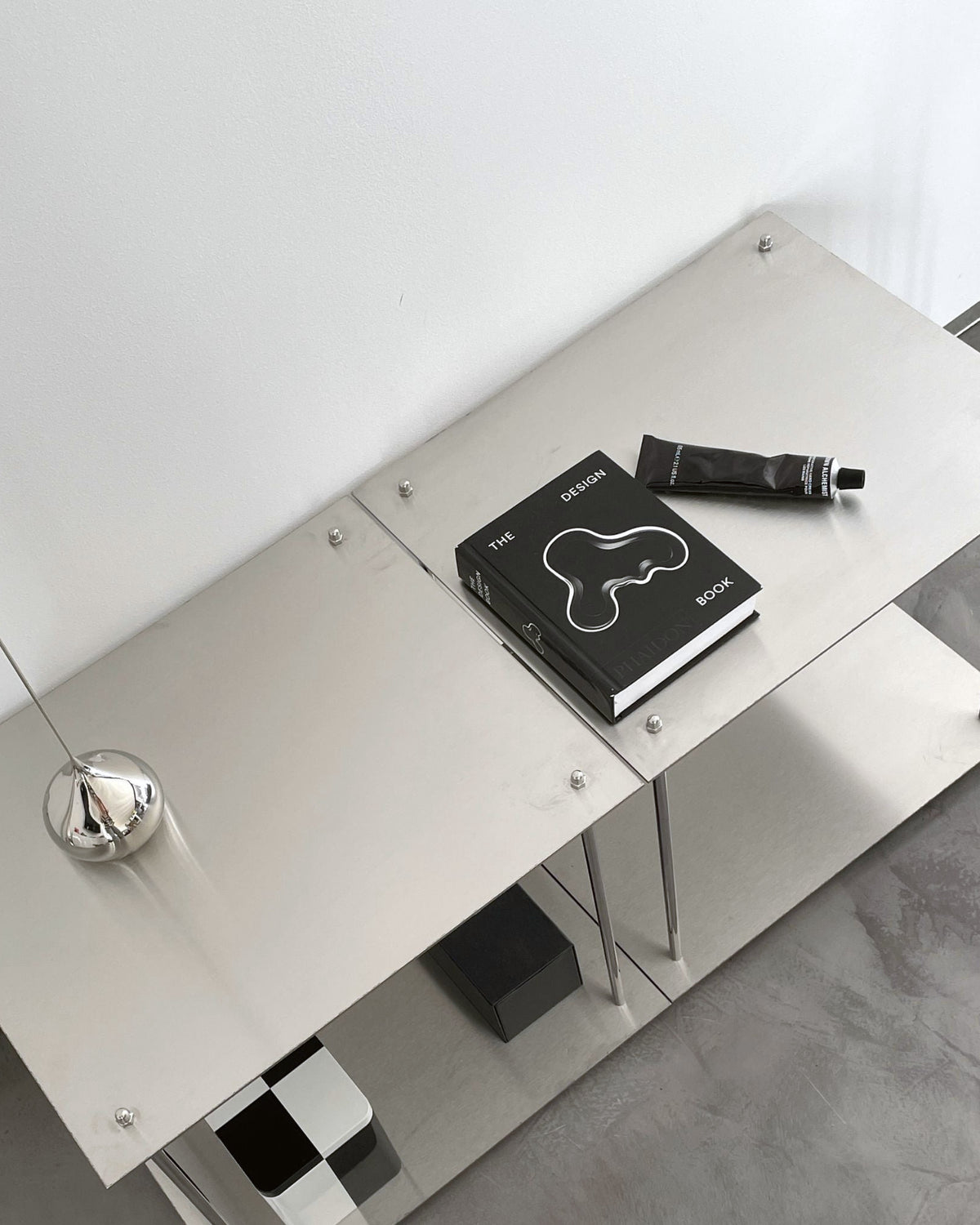 Modernes Lowboard aus Edelstahl mit Design-Accessoires und Büchern