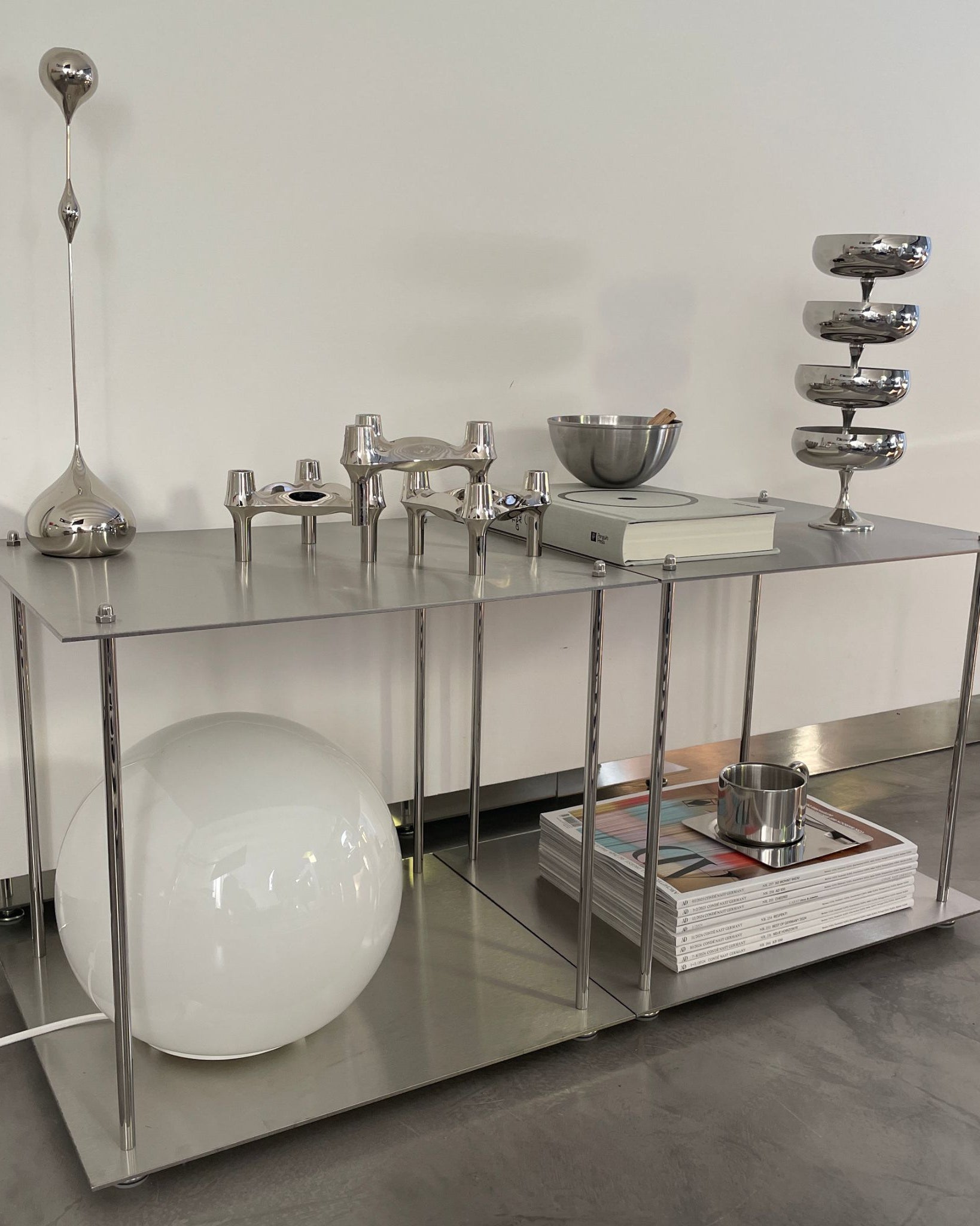 Modulares Lowboard aus Edelstahl mit Design-Accessoires und dekorativen Elementen