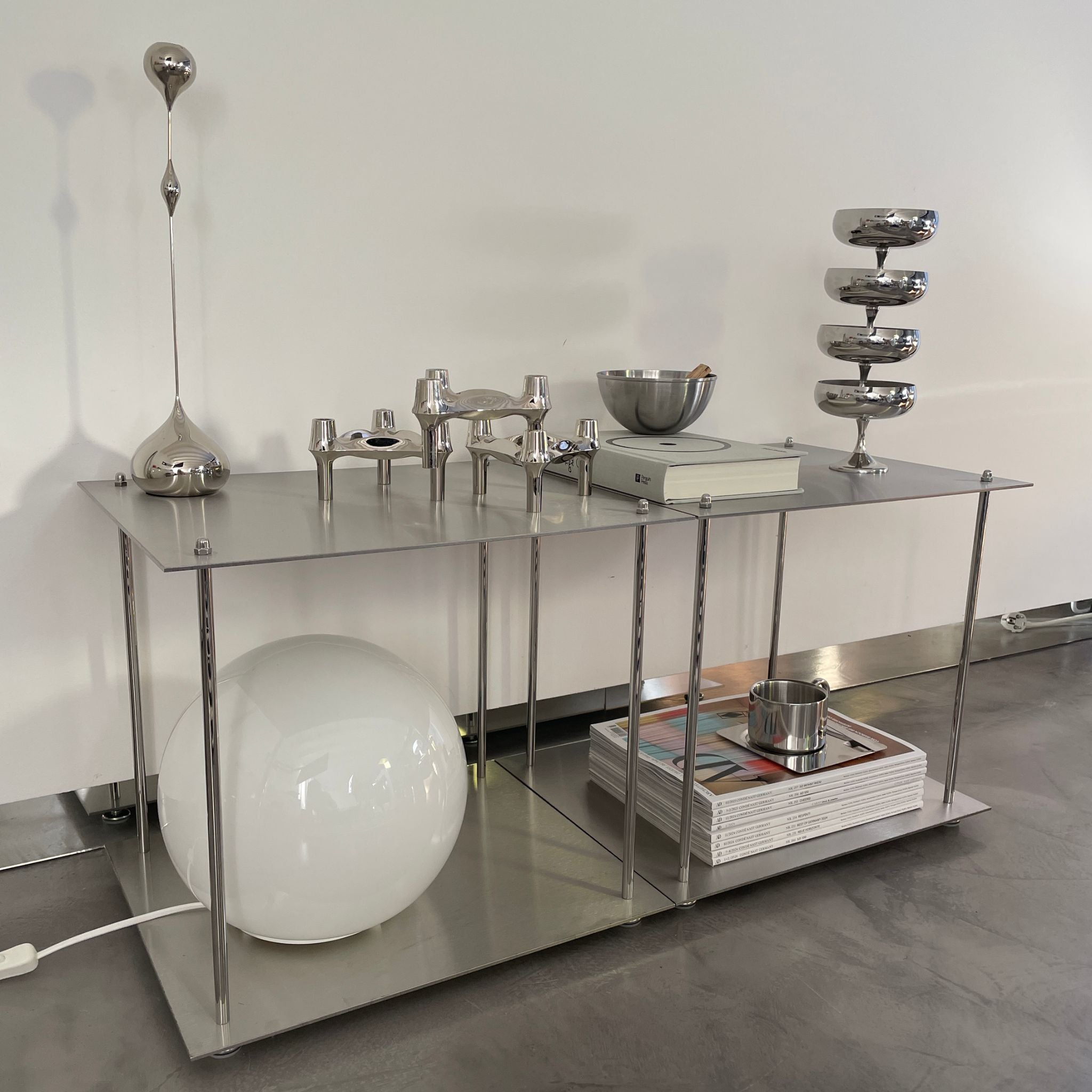 Modulares Lowboard aus Edelstahl mit Design-Accessoires und dekorativen Elementen