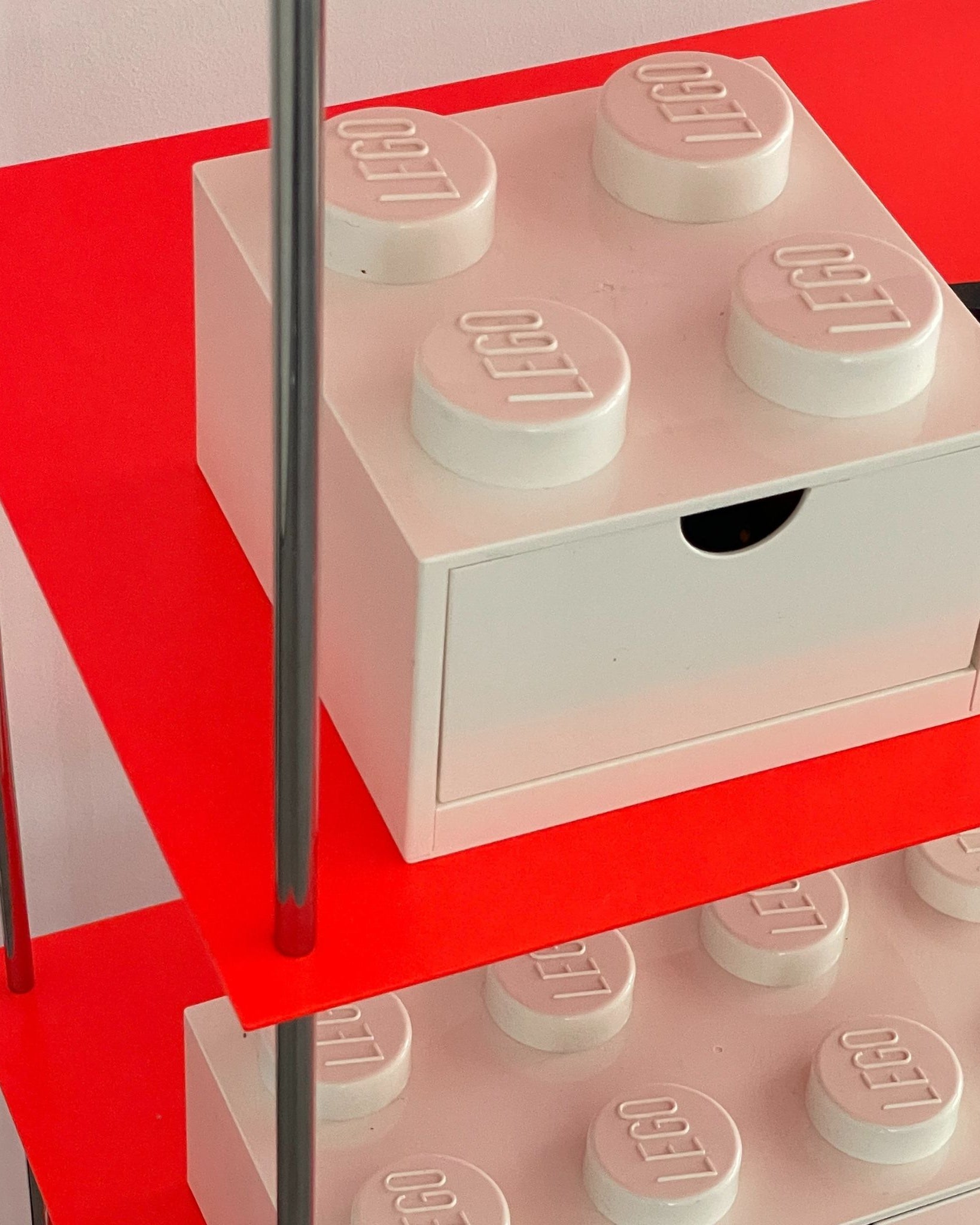 Nahaufnahme Regalboden in Leuchtrot mit weißer Lego-Schublade
