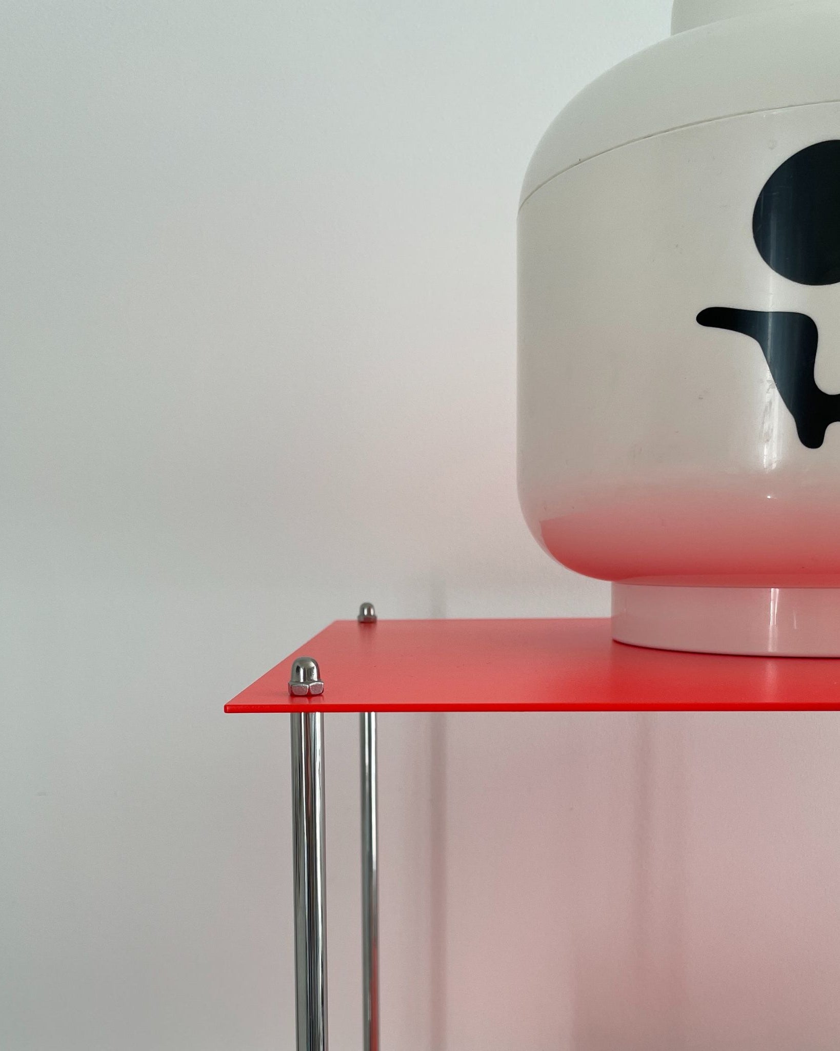 Leuchtrotes Regal mit weißem Lego-Kopf mit Totenkopf-Gesicht