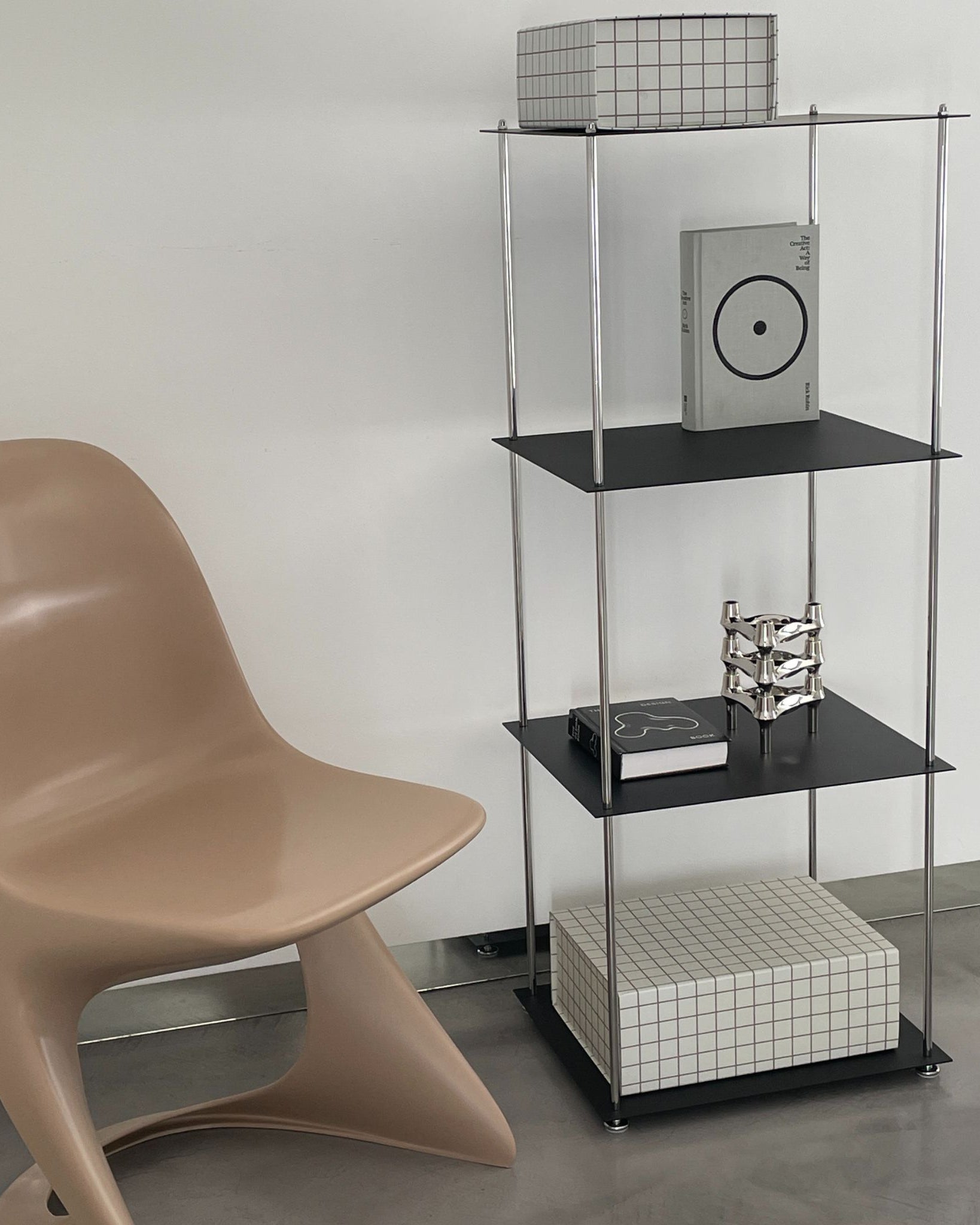 Schwarzes Regal von MO INTERIORS mit Designstuhl, Rasterbox und Dekoobjekten im modernen Interieur