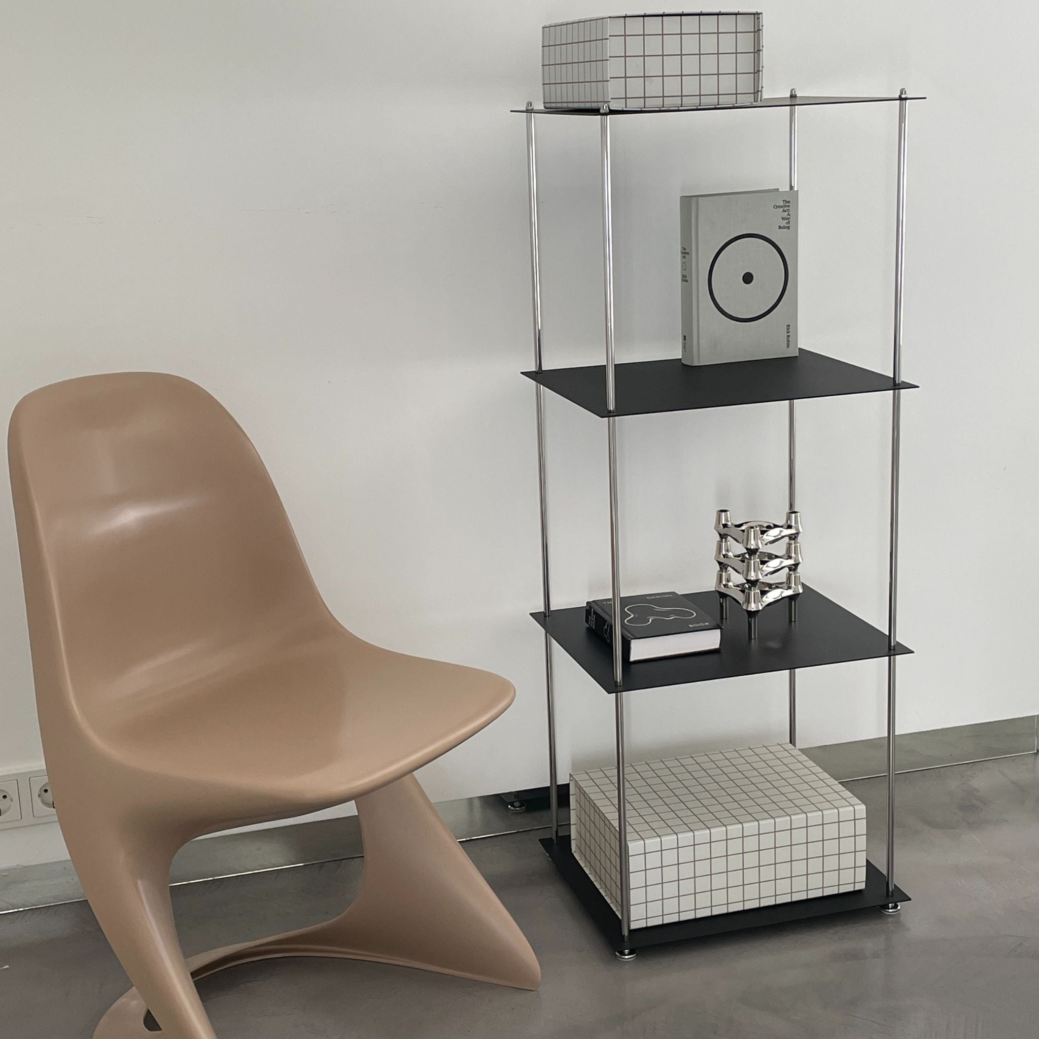 Schwarzes Regal von MO INTERIORS mit Designstuhl, Rasterbox und Dekoobjekten im modernen Interieur