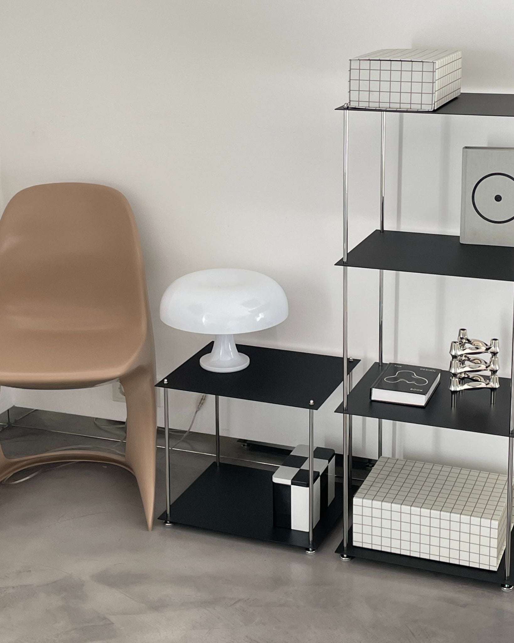 MO INTERIORS Regal und Beistelltisch in Schwarz mit Designobjekten, weißer Lampe und Stuhl im modernen Wohnraum