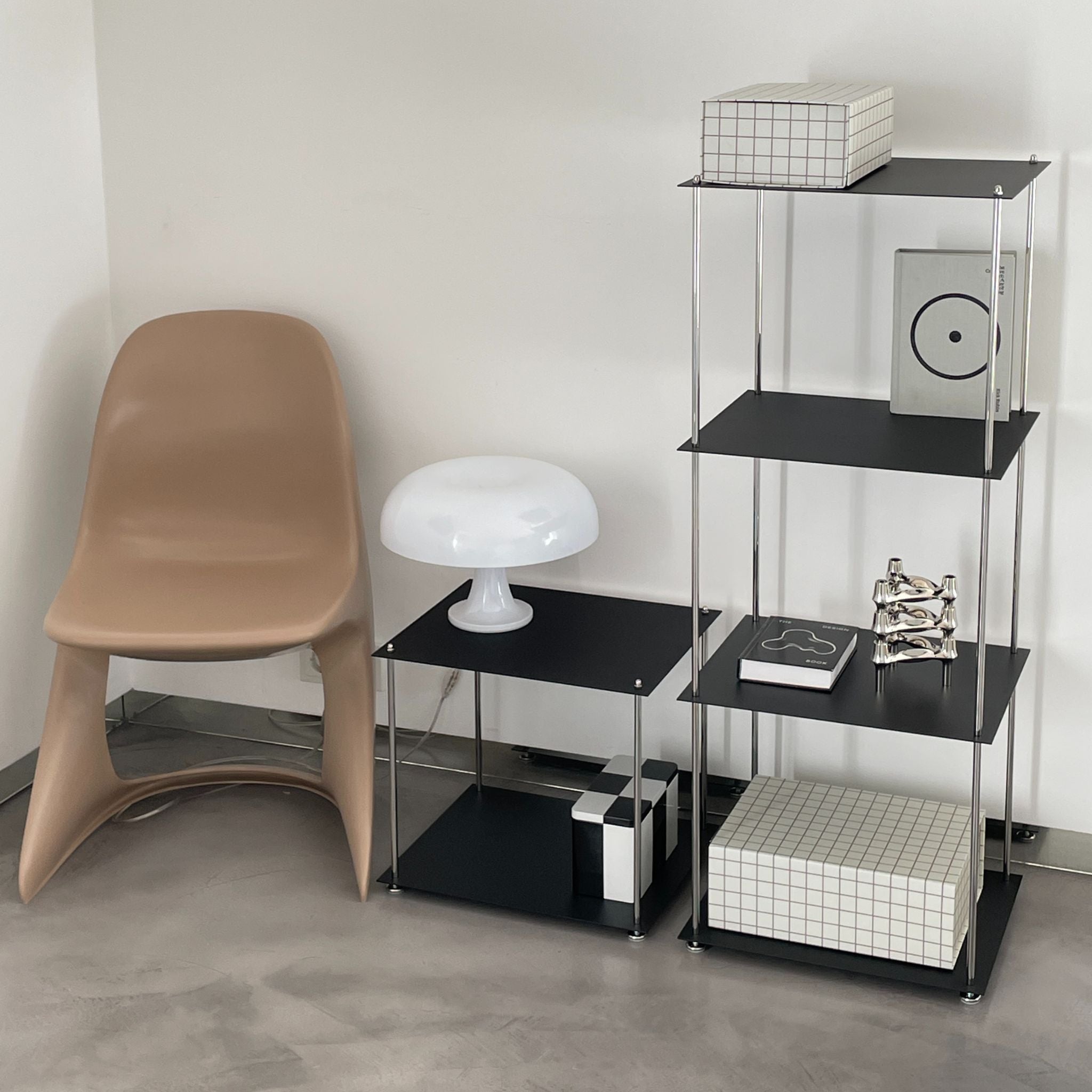 MO INTERIORS Regal und Beistelltisch in Schwarz mit Designobjekten, weißer Lampe und Stuhl im modernen Wohnraum