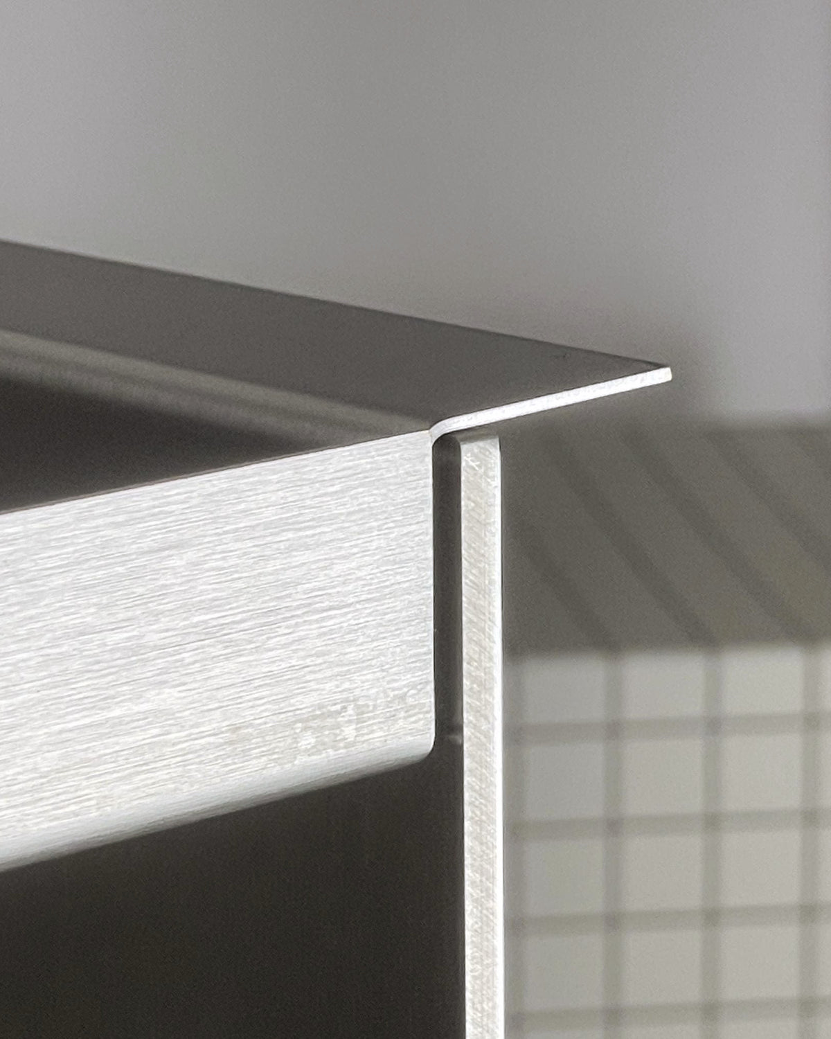 Detailansicht Edelstahl Tray Table von MO INTERIORS mit präzise gebogener Kante und gebürsteter Oberfläche.