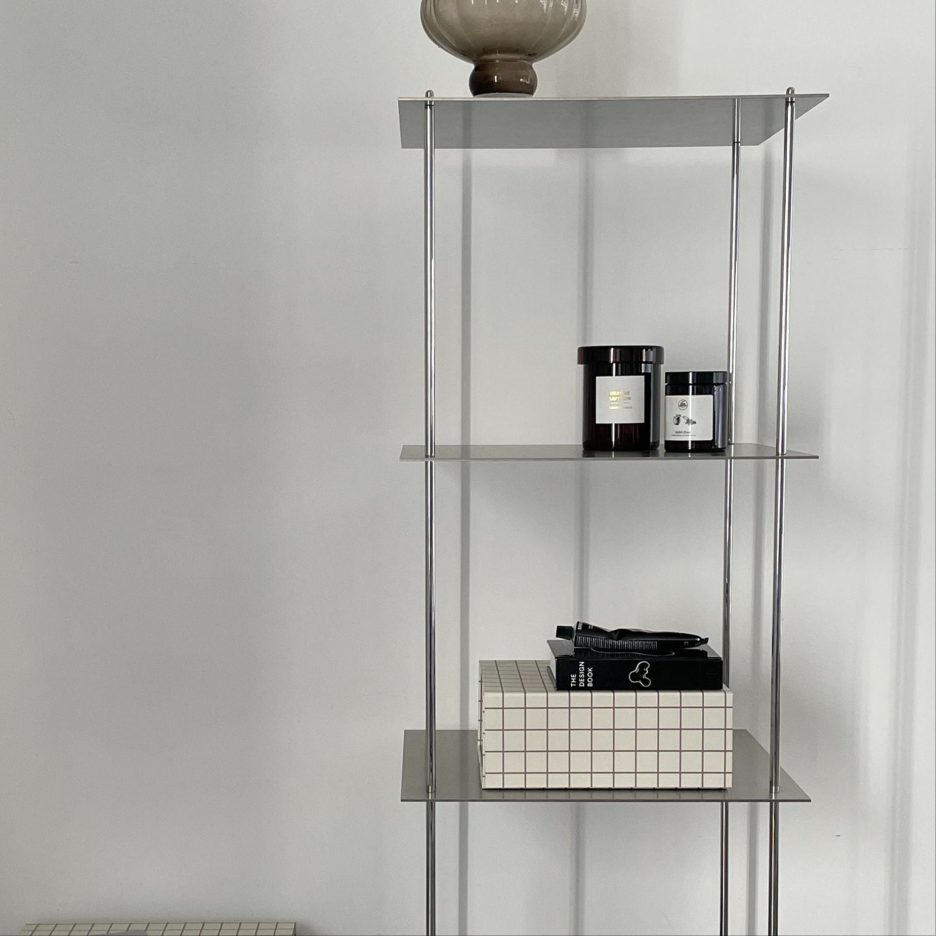 Hohes modulares Edelstahl-Regal mit minimalistischer Ästhetik und stilvoller Dekoration