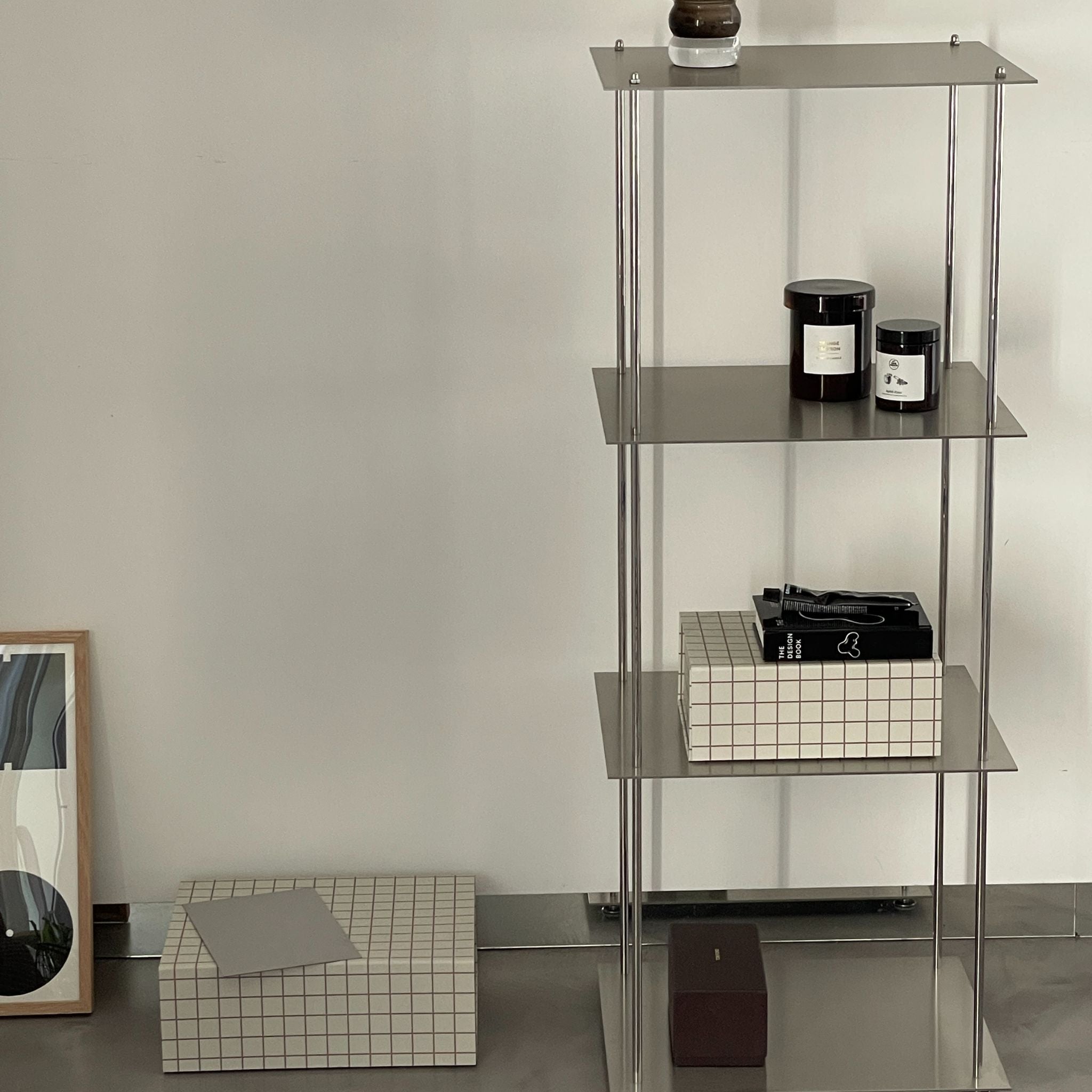 Modulares Regal aus Edelstahl mit Duftkerzen, Büchern und Boxen im minimalistischen Stil