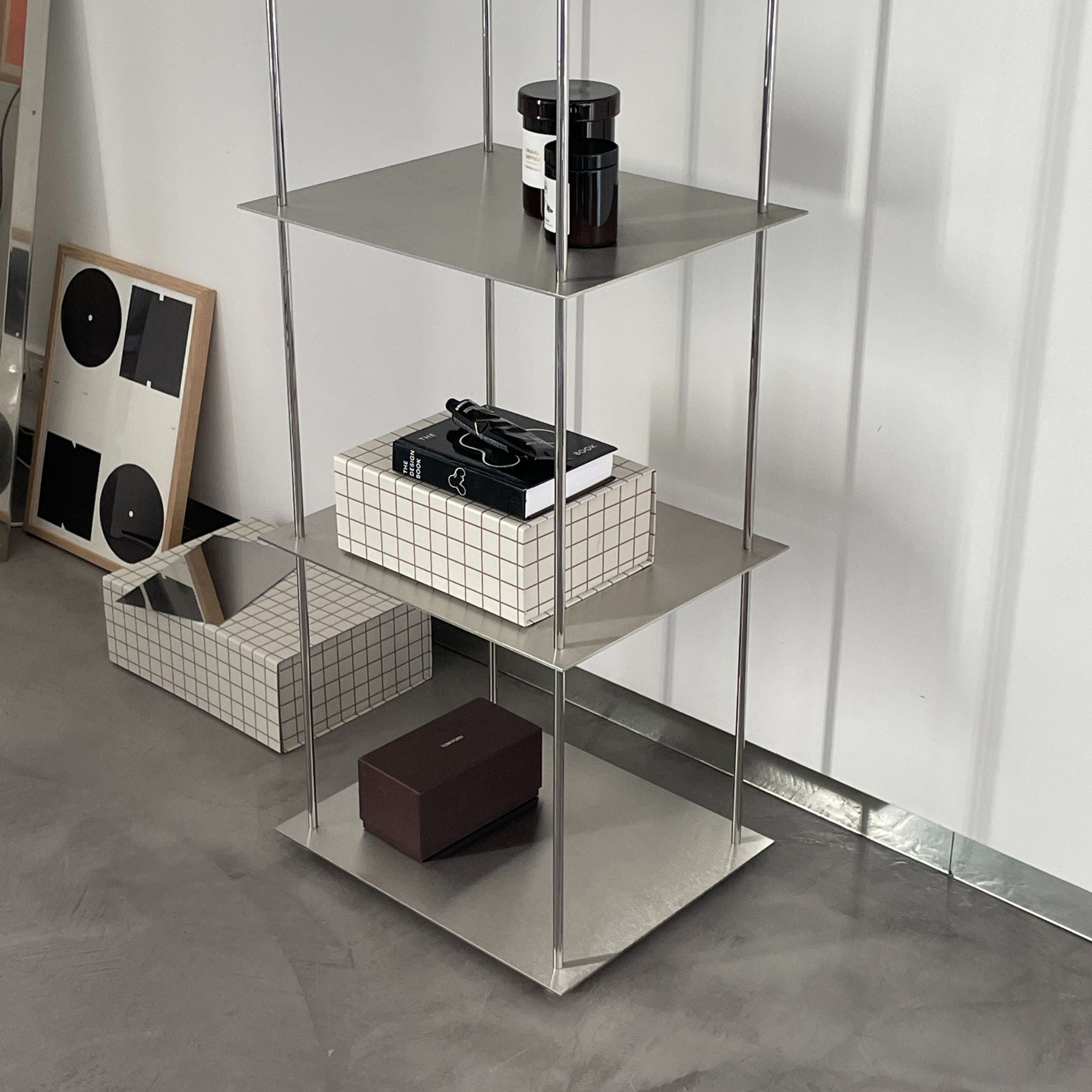 Modernes Edelstahl-Regal mit minimalistischer Dekoration und geometrischen Boxen