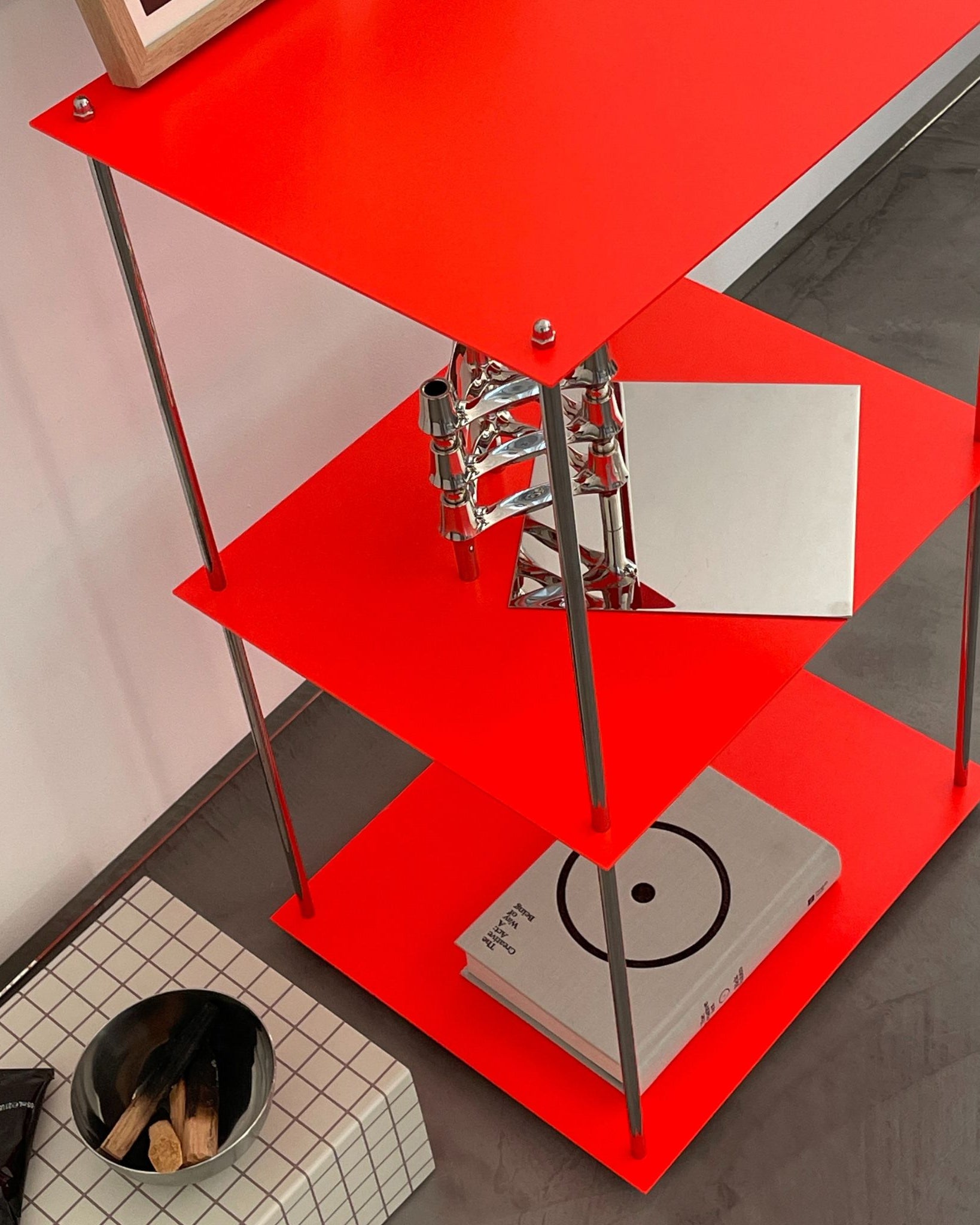 Detailansicht des modularen Regals in Leuchtrot mit Designobjekten, pulverbeschichtet von MO INTERIORS