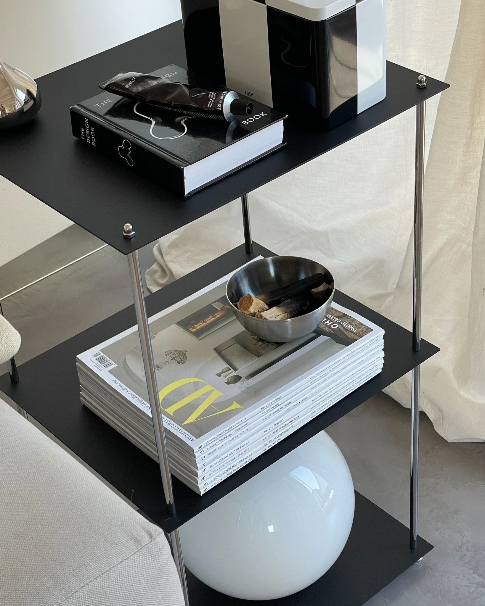 Modernes schwarzes Regal mit pulverbeschichteten Böden und Designobjekten im Wohnzimmer