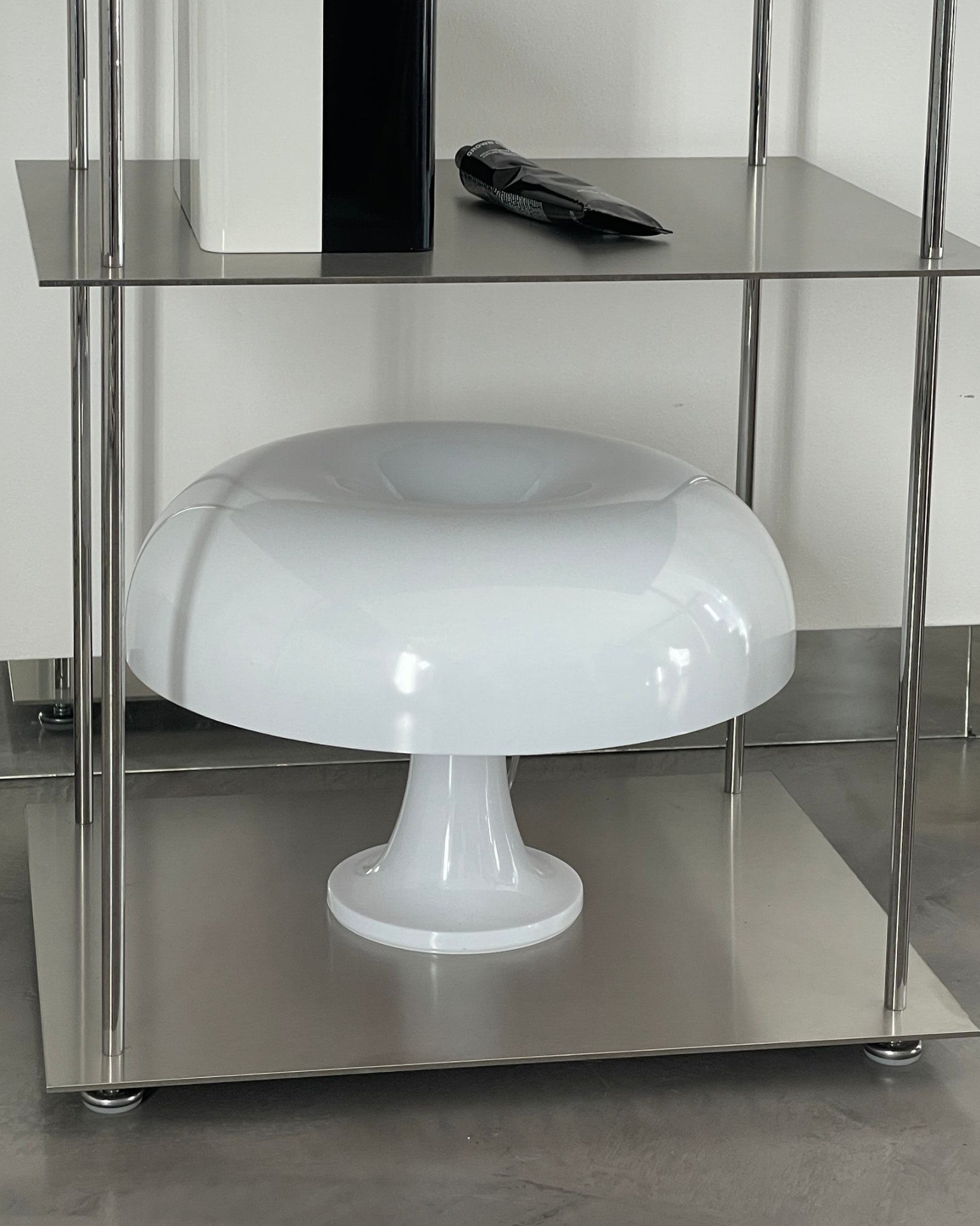 Detailansicht eines modularen Edelstahl-Regals mit Designerlampe und stilvollen Accessoires