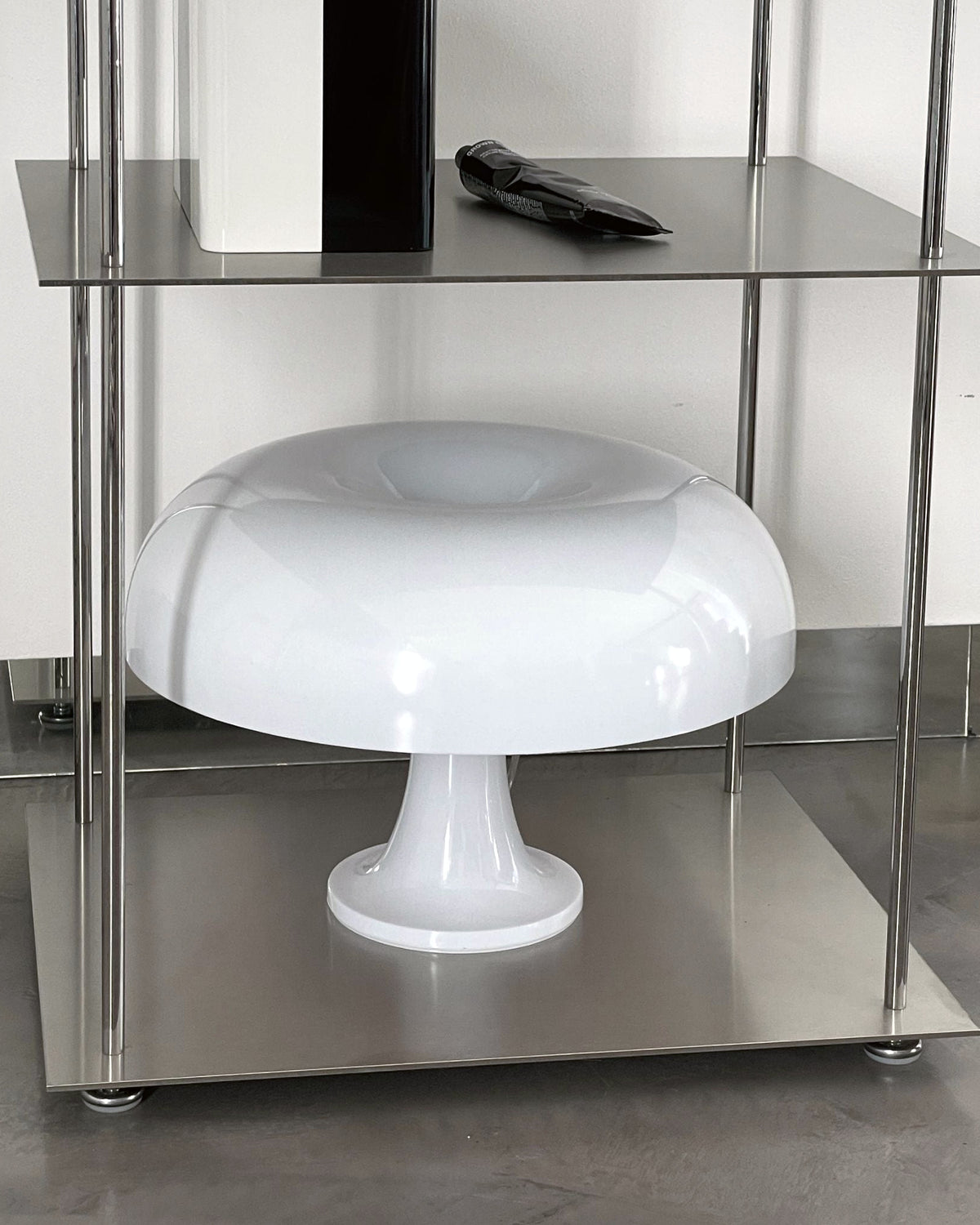 Detailansicht eines modularen Edelstahl-Regals mit Designerlampe und stilvollen Accessoires